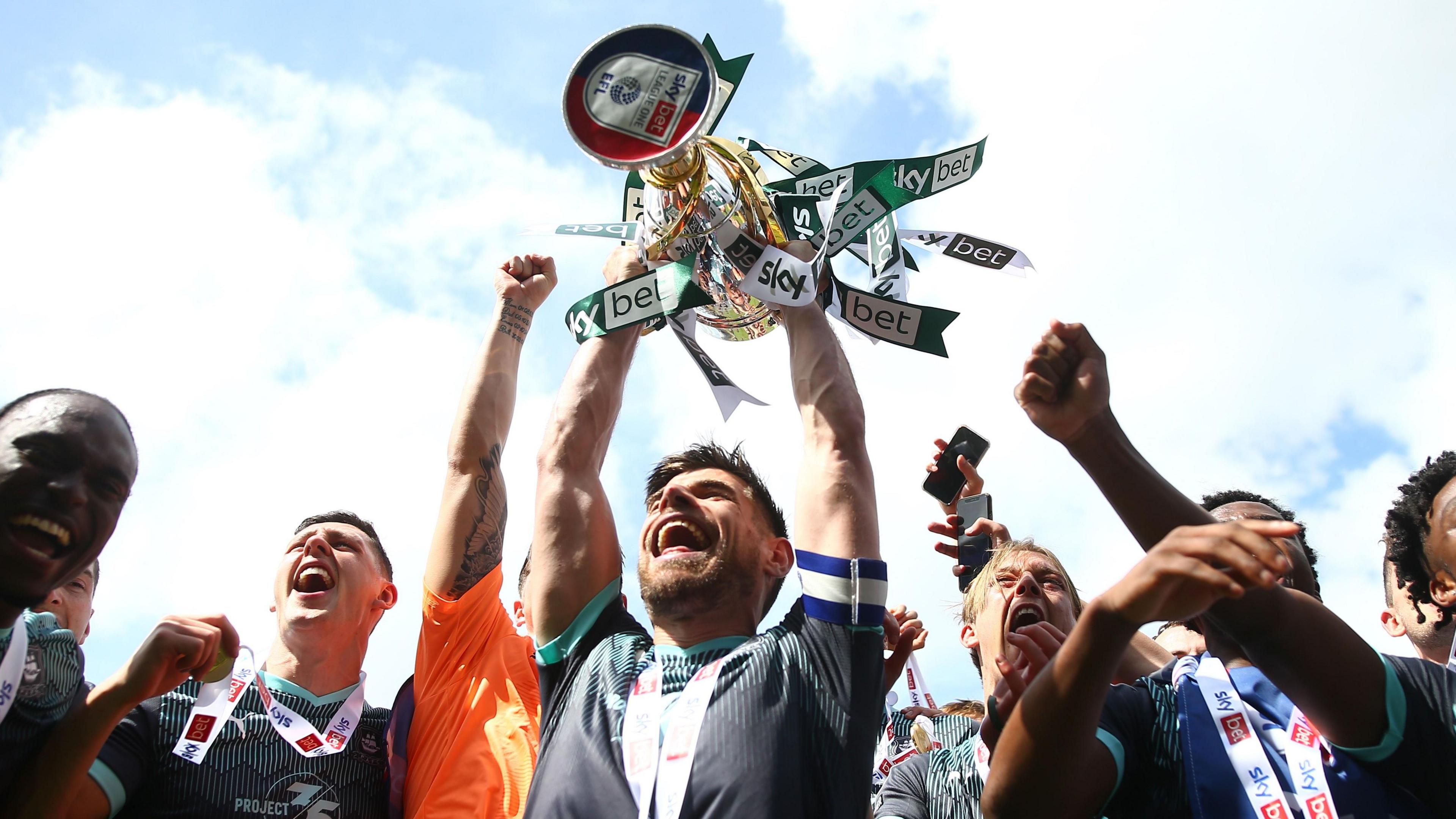 Joe Edwards lifts the League One trophy