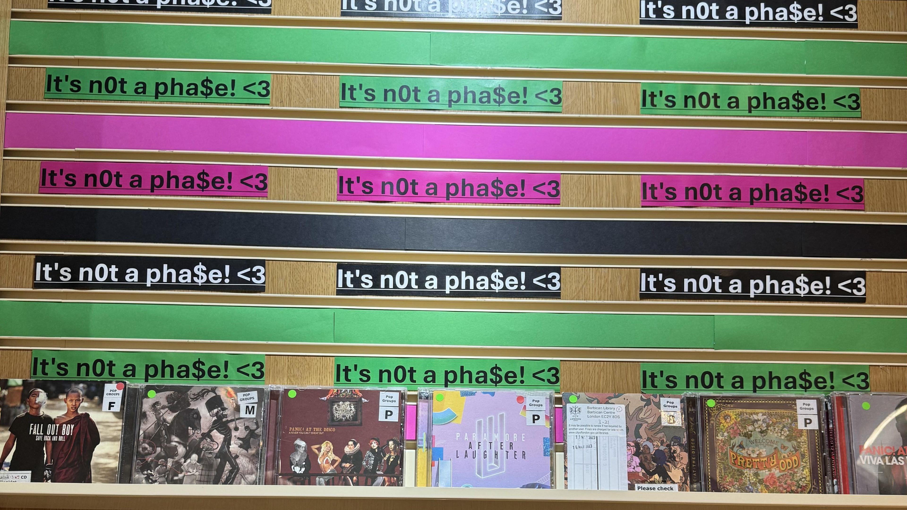 A CD stand with the phrase "It's not a phase" written above multiple times.
