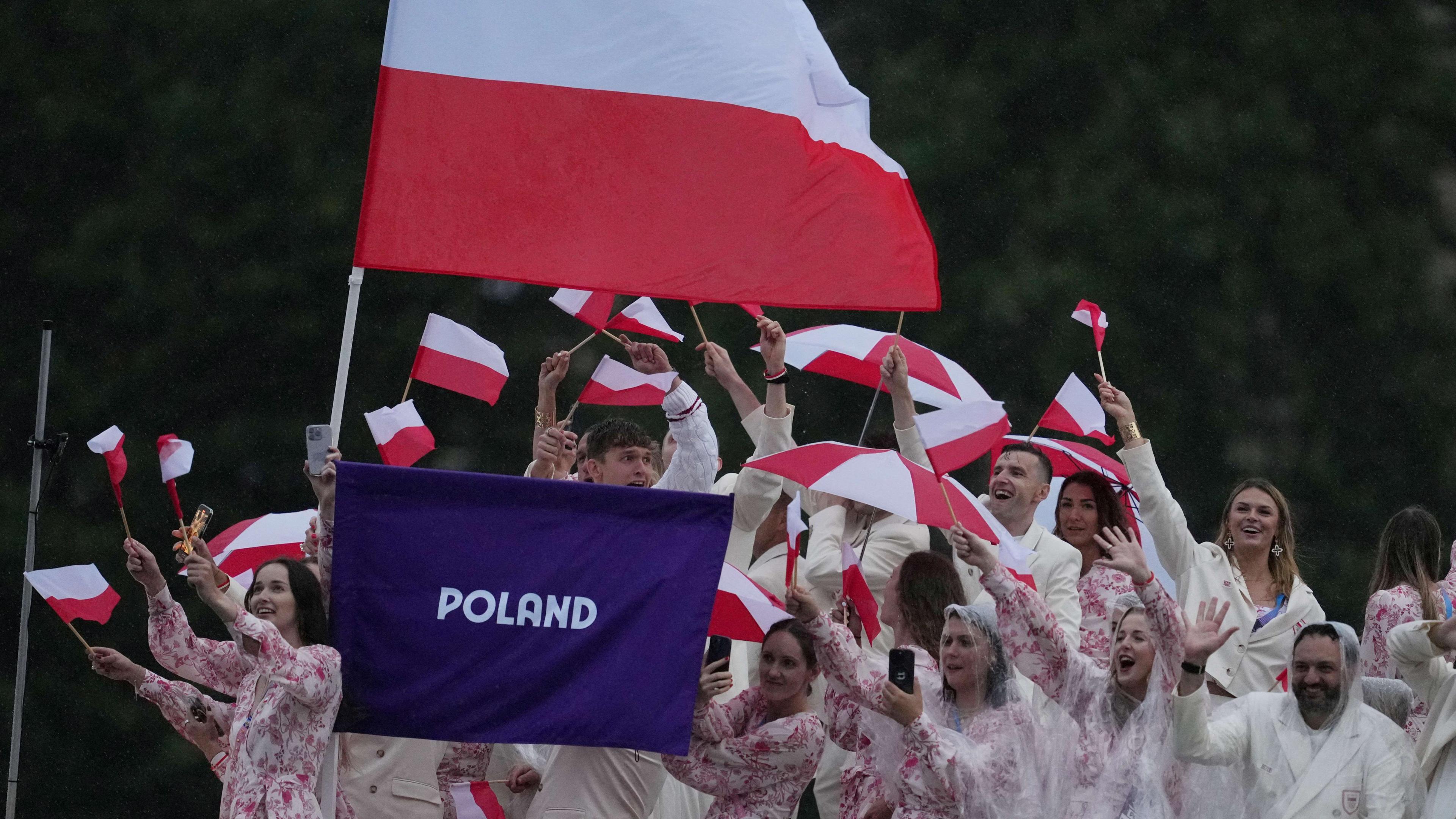 Athletes of Poland aboard a boat in the floating parade on the river Seine during the opening ceremony of Paris 2024.