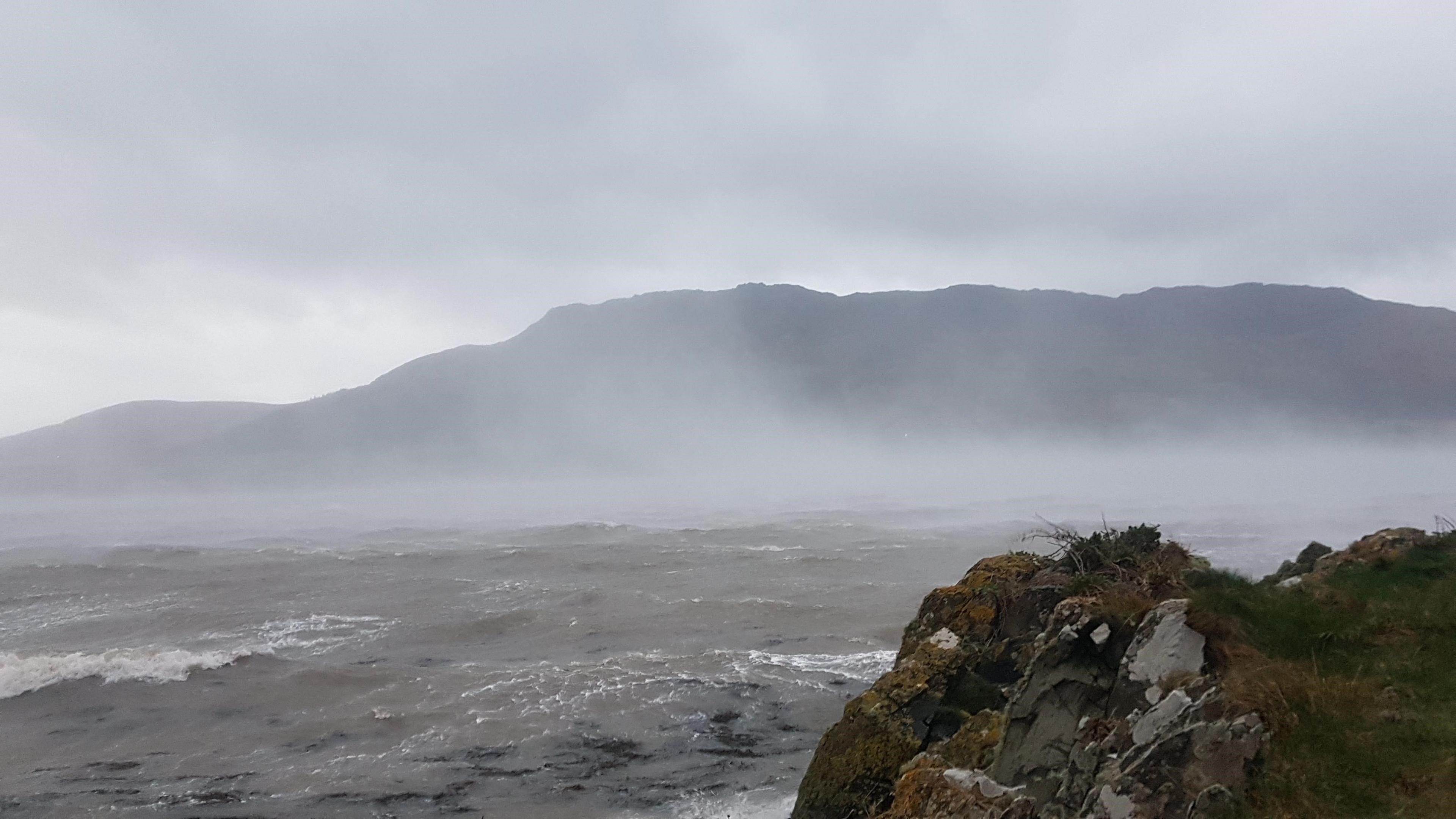 A rough sea with mist rising from it sue to the wind.