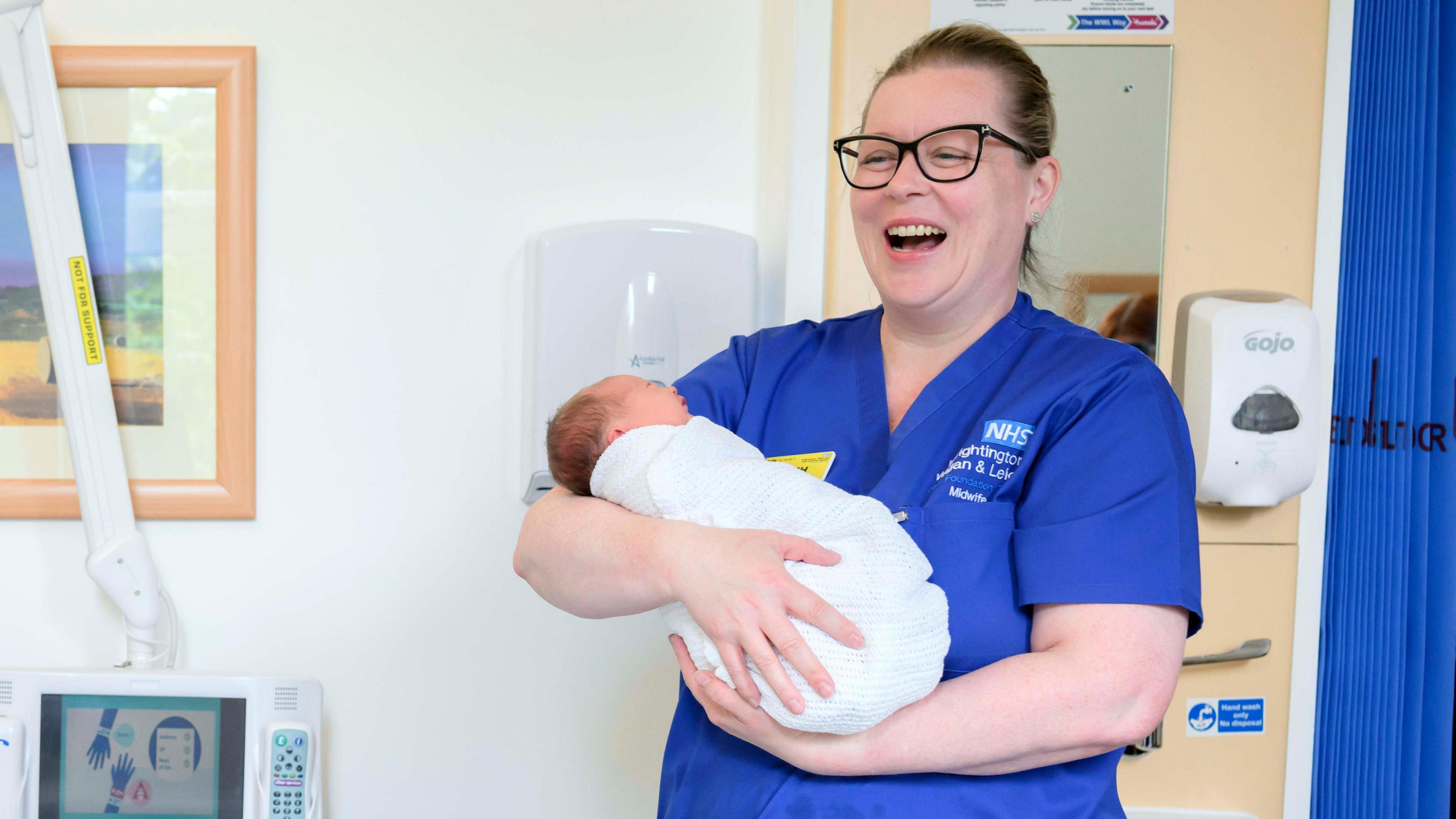 Ruth Breen holding a newborn baby she helped