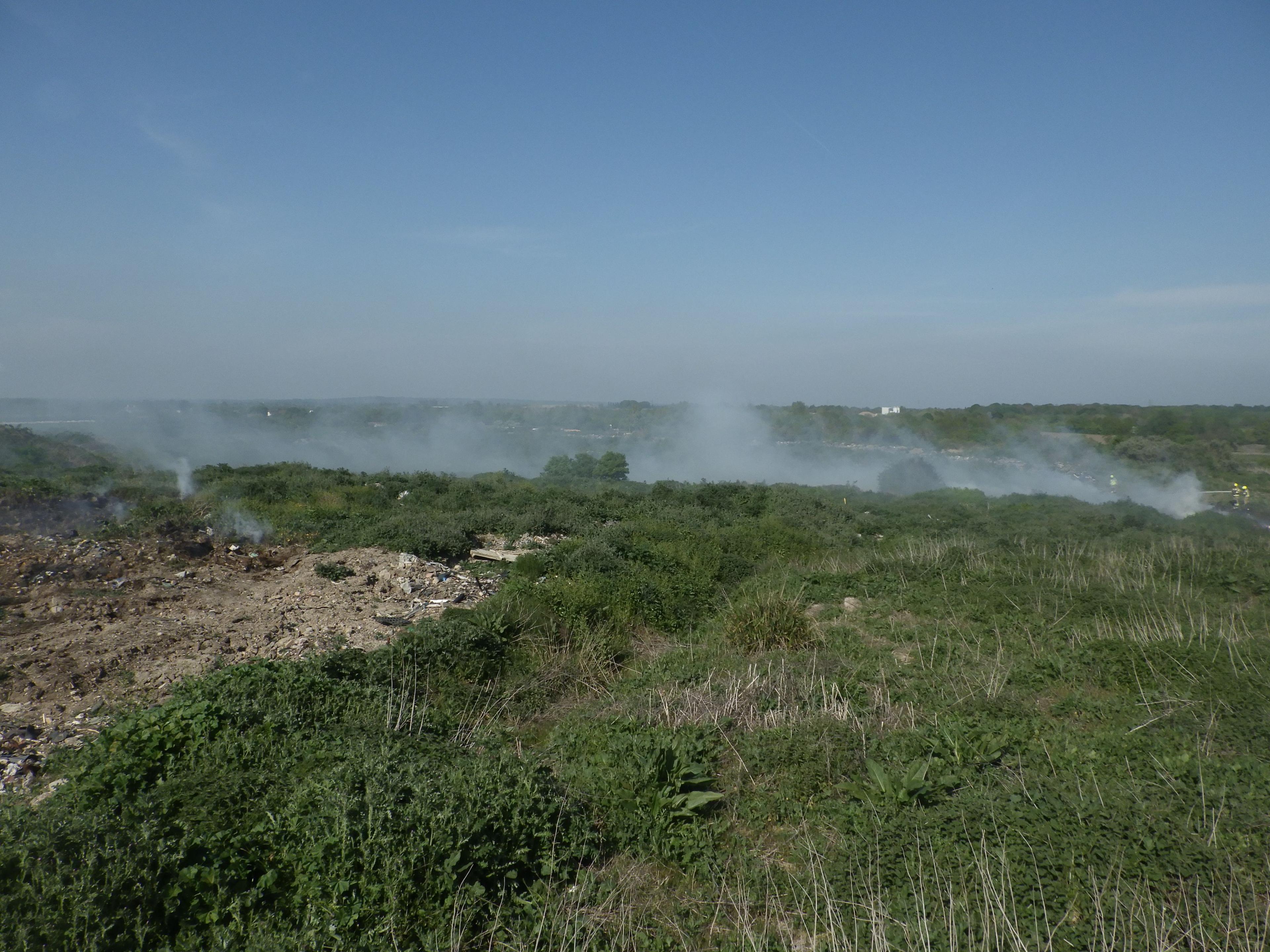 Smoke smoulders in a scrubby field