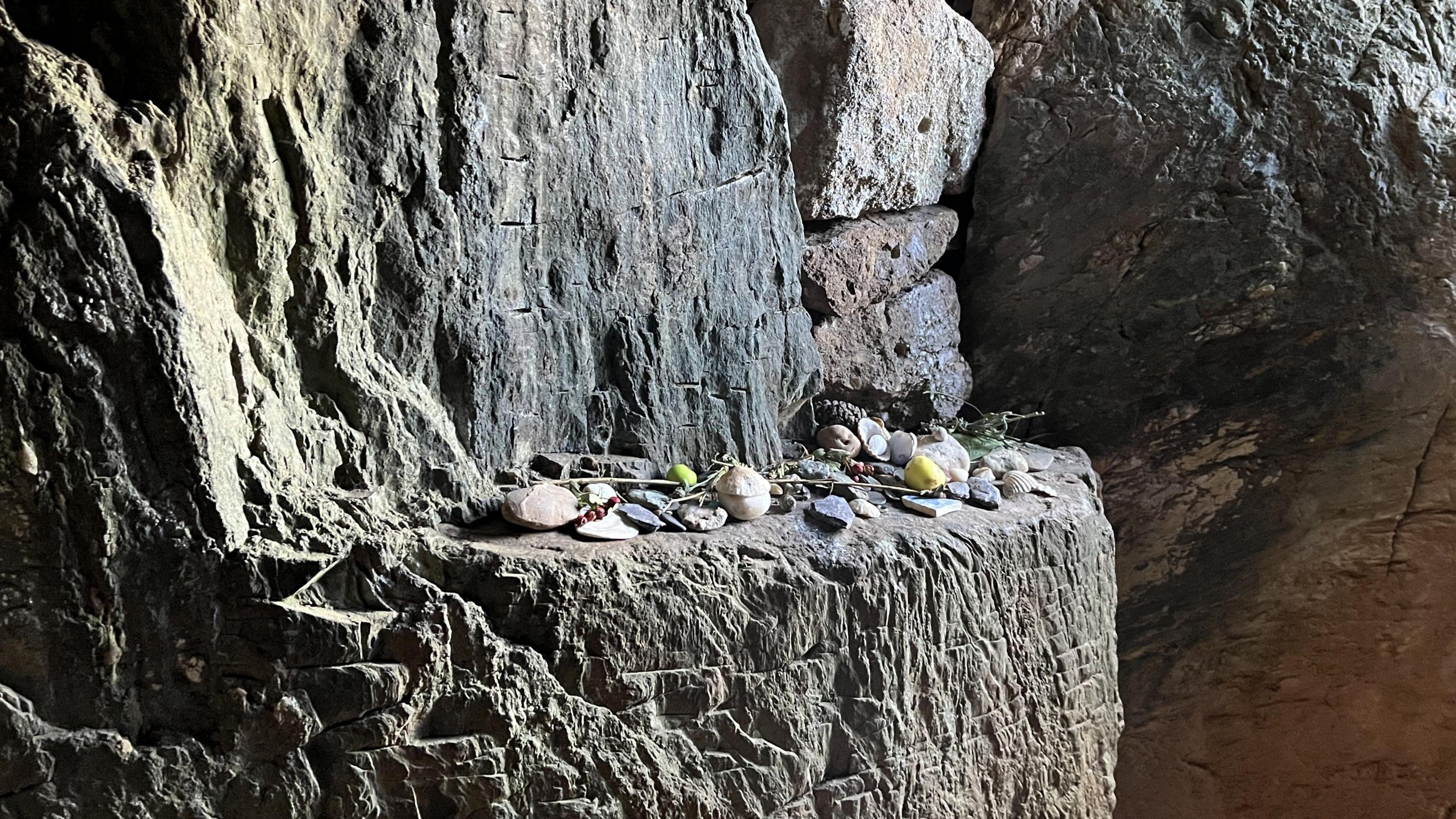 Mae marciau paent, crafiadau ac eitemau'n cael eu gadael y tu mewn i Bryn Celli Ddu