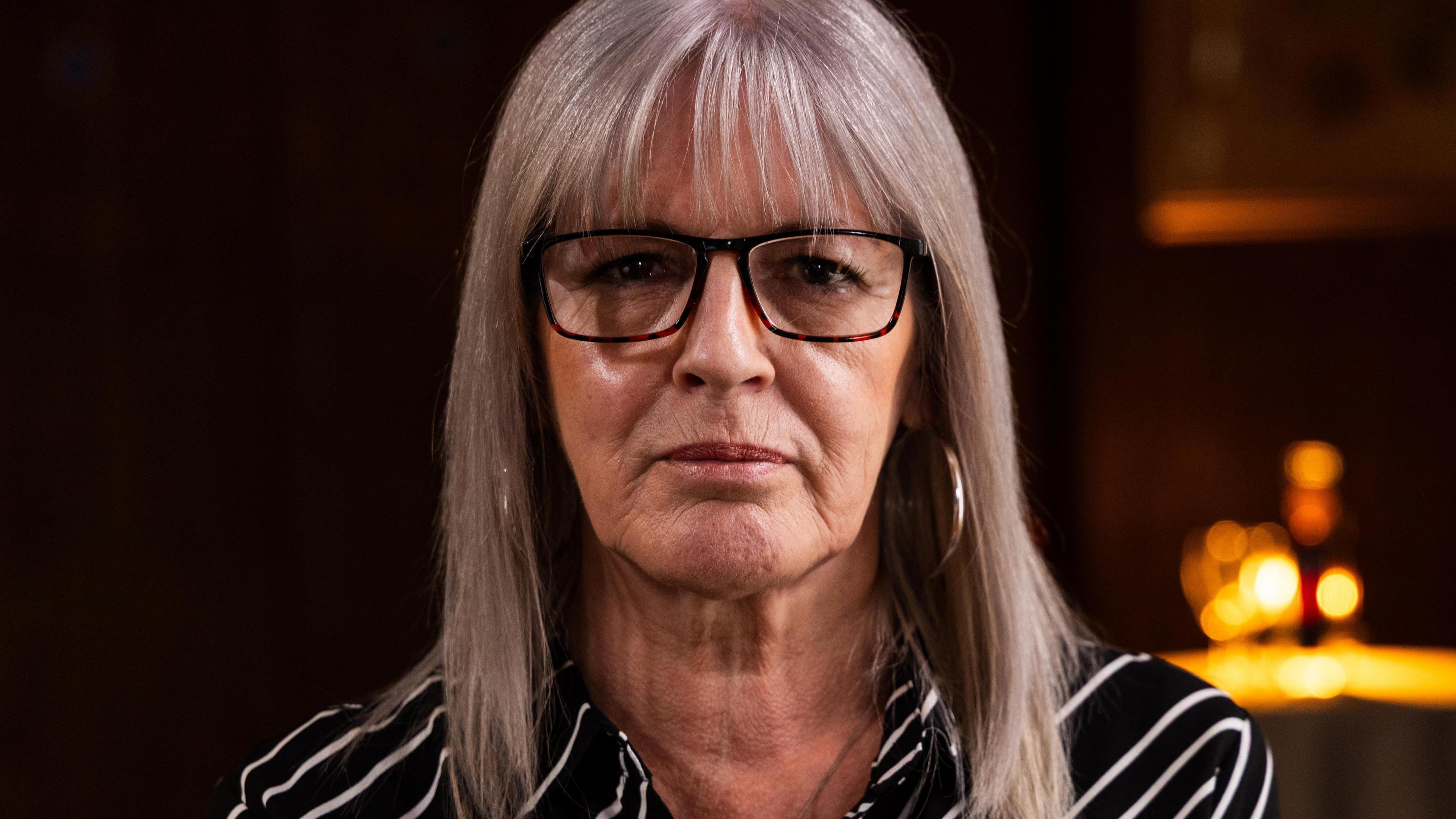 A photo of Caroline looking directly at the camera. She has blonde hair and wears glasses.