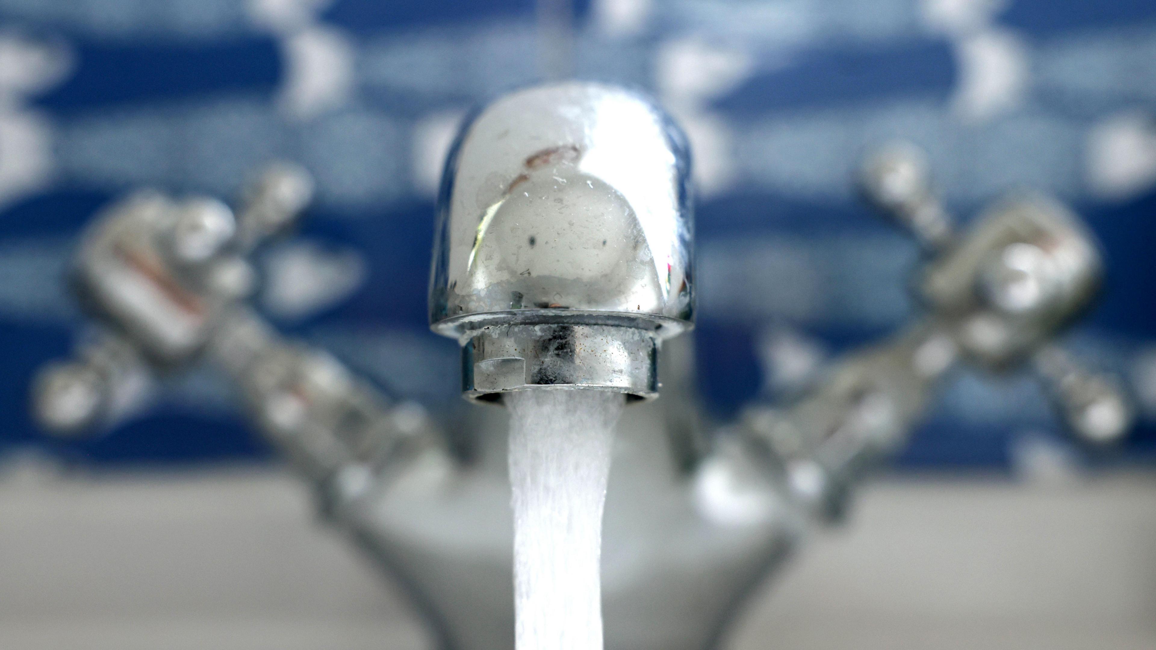 Close up image of a tap, with water coming out of the spout