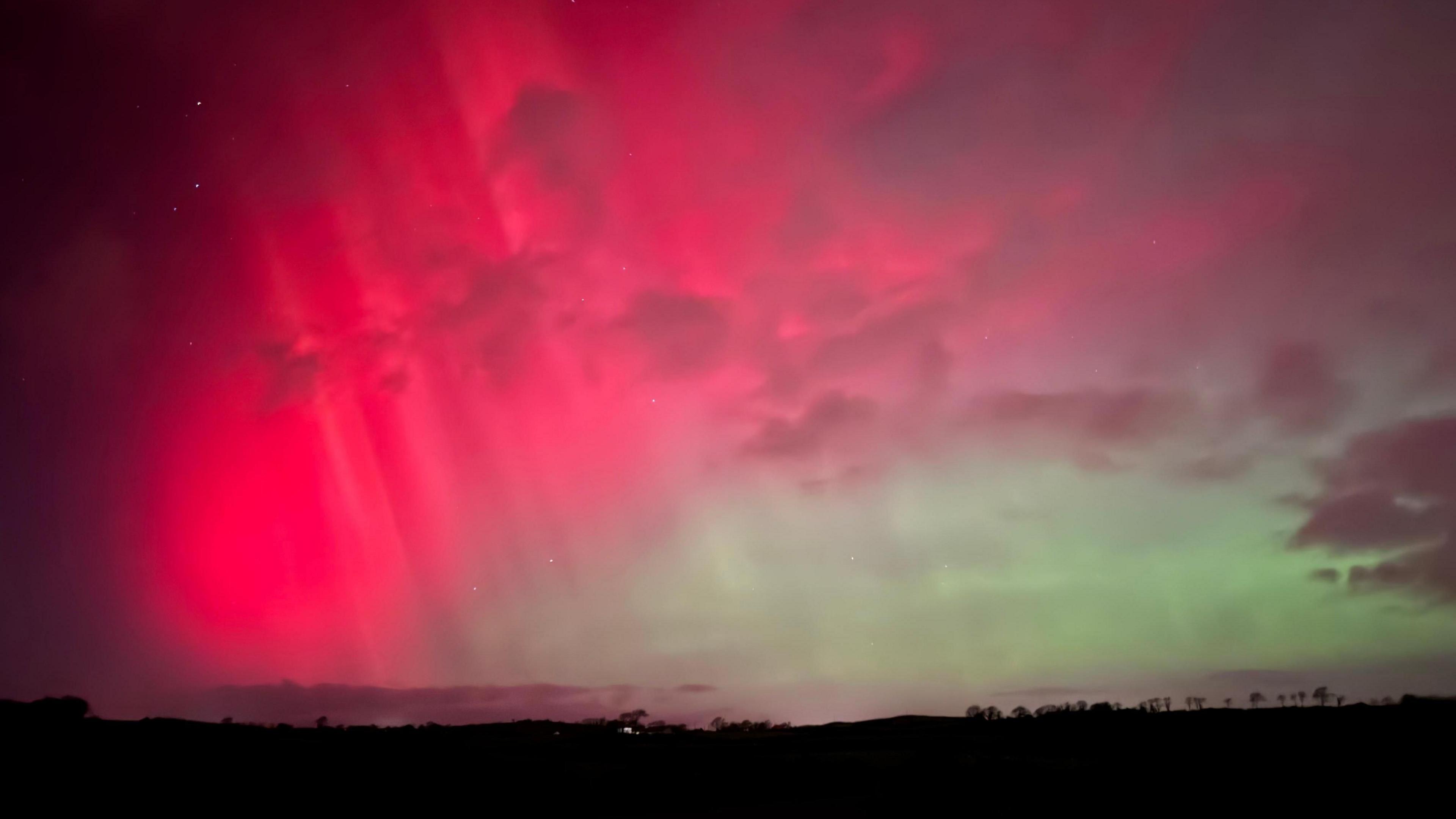 The Northern Lights lighting up the sky in shades of green and pink. 