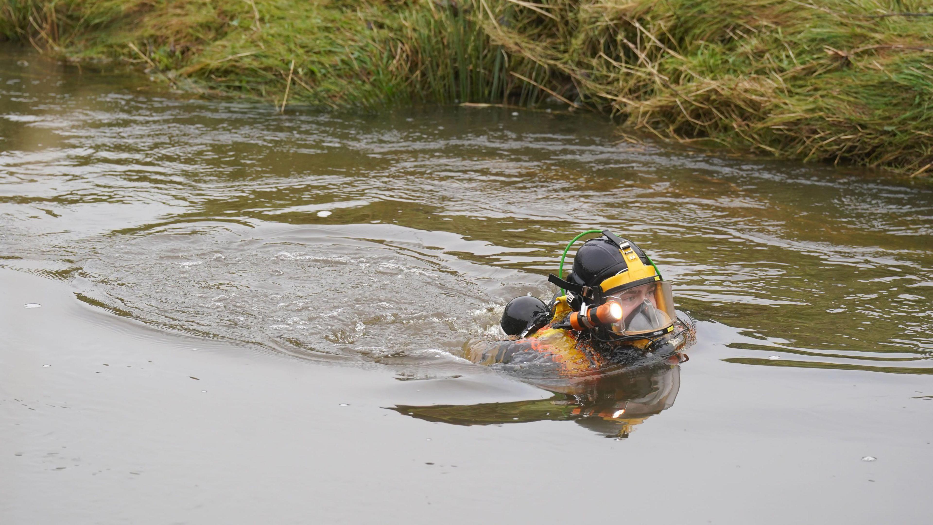 A diver searching in the river.