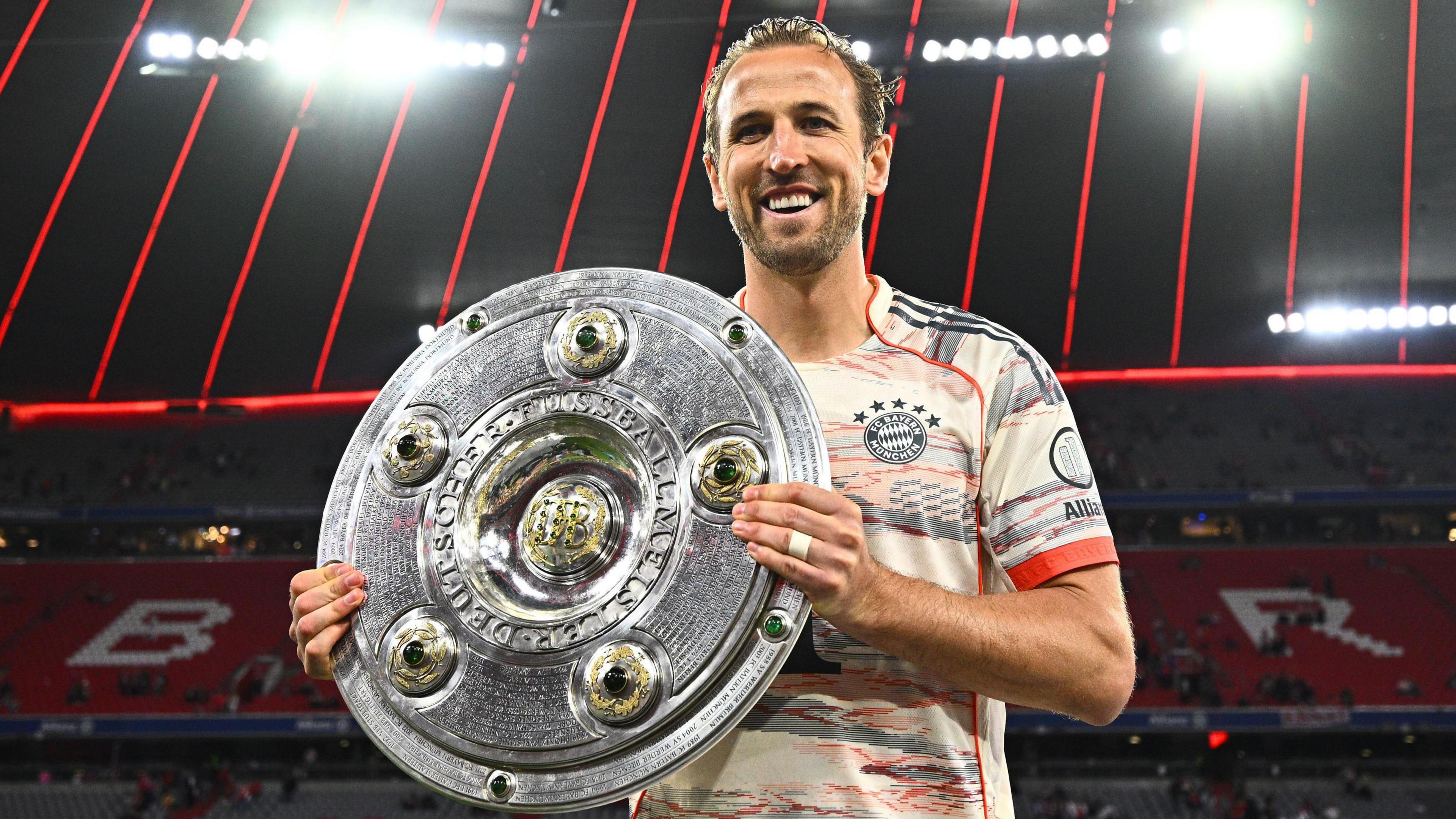 Harry Kane poses with the Bundesliga trophy