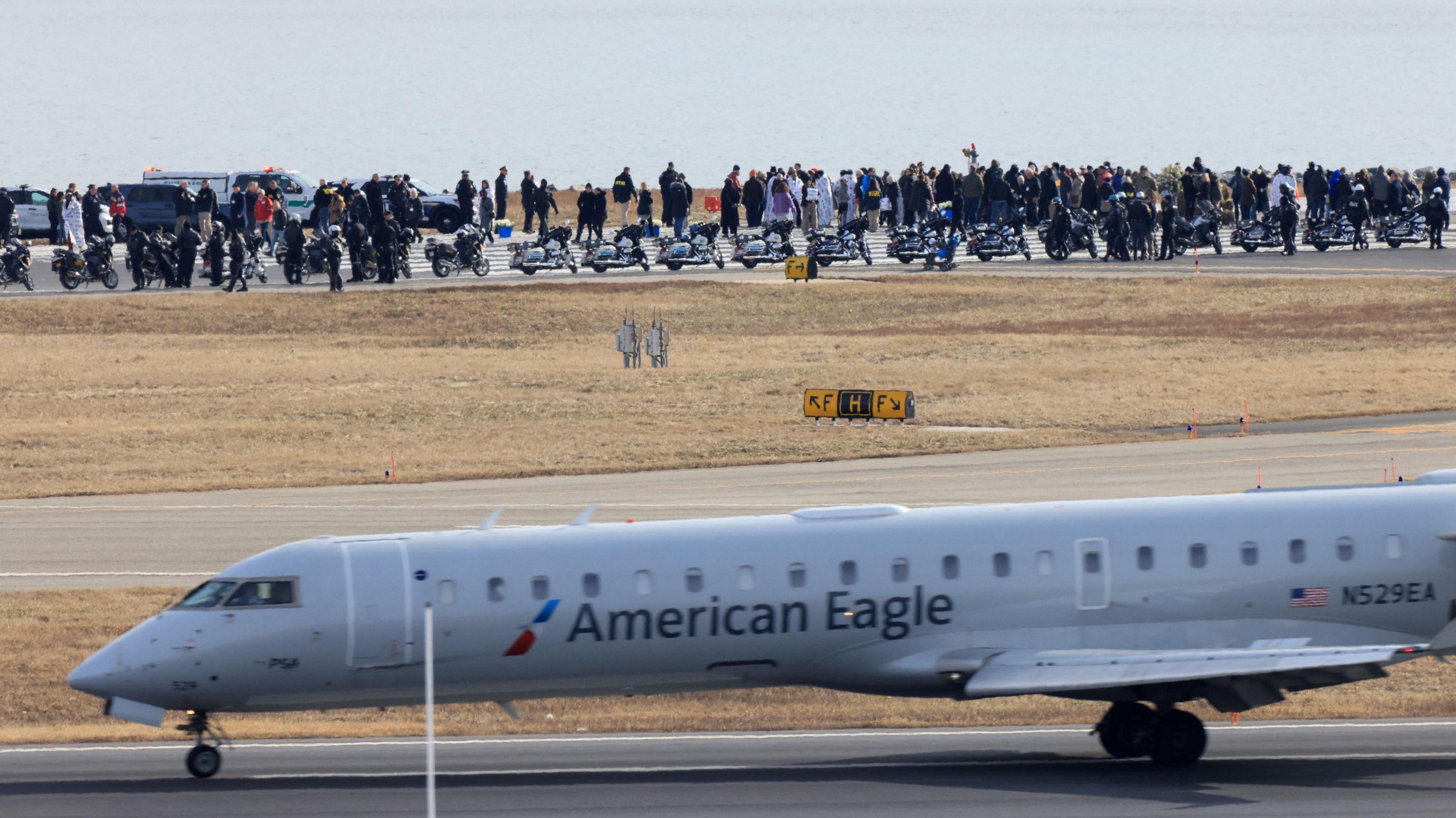 Family members of victims of the deadly collision of American Eagle flight 5342 and the helicopter that crashed into the Potomac River, stand near the river, at the Ronald Reagan Washington National Airport, in Arlington, Virginia, U.S., February 2, 2025.