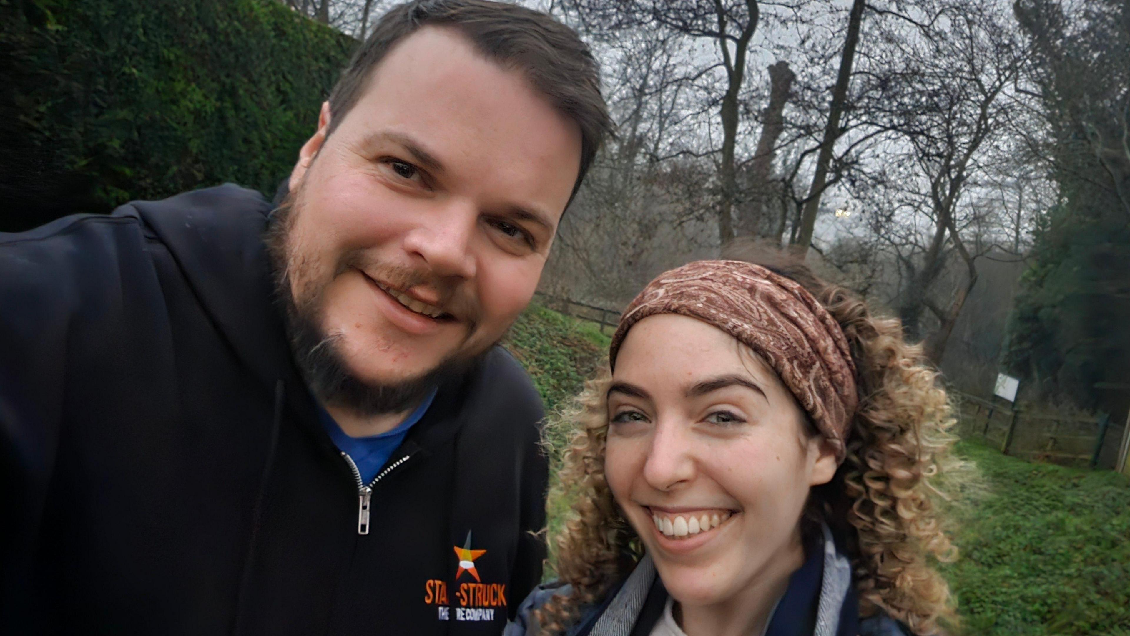 A selfie taken by a bearded Aaron Wilkes, standing outside next to Freya, a fellow musician with long, curly hair