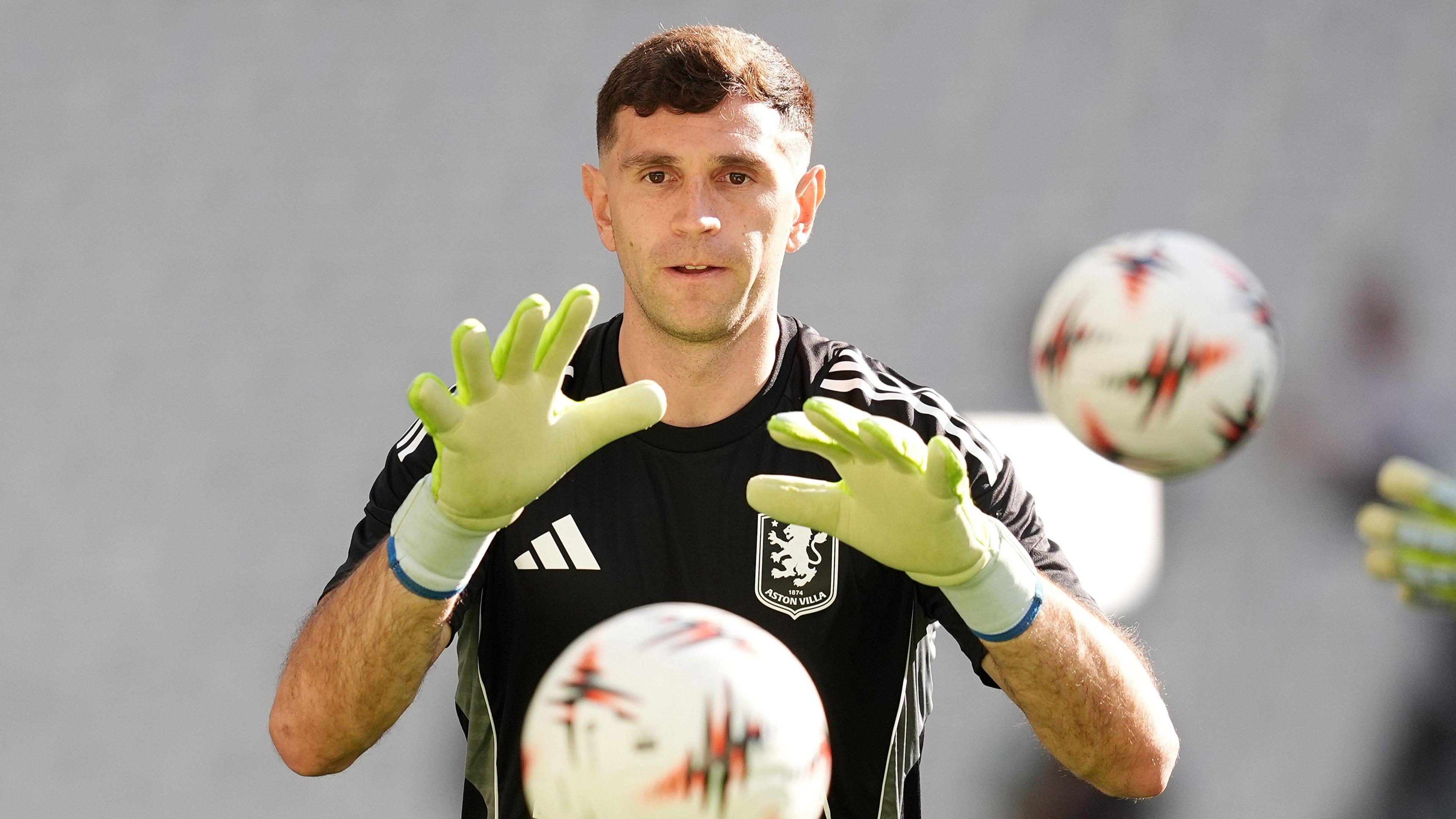 Emi Martinez catches a ball during a training session