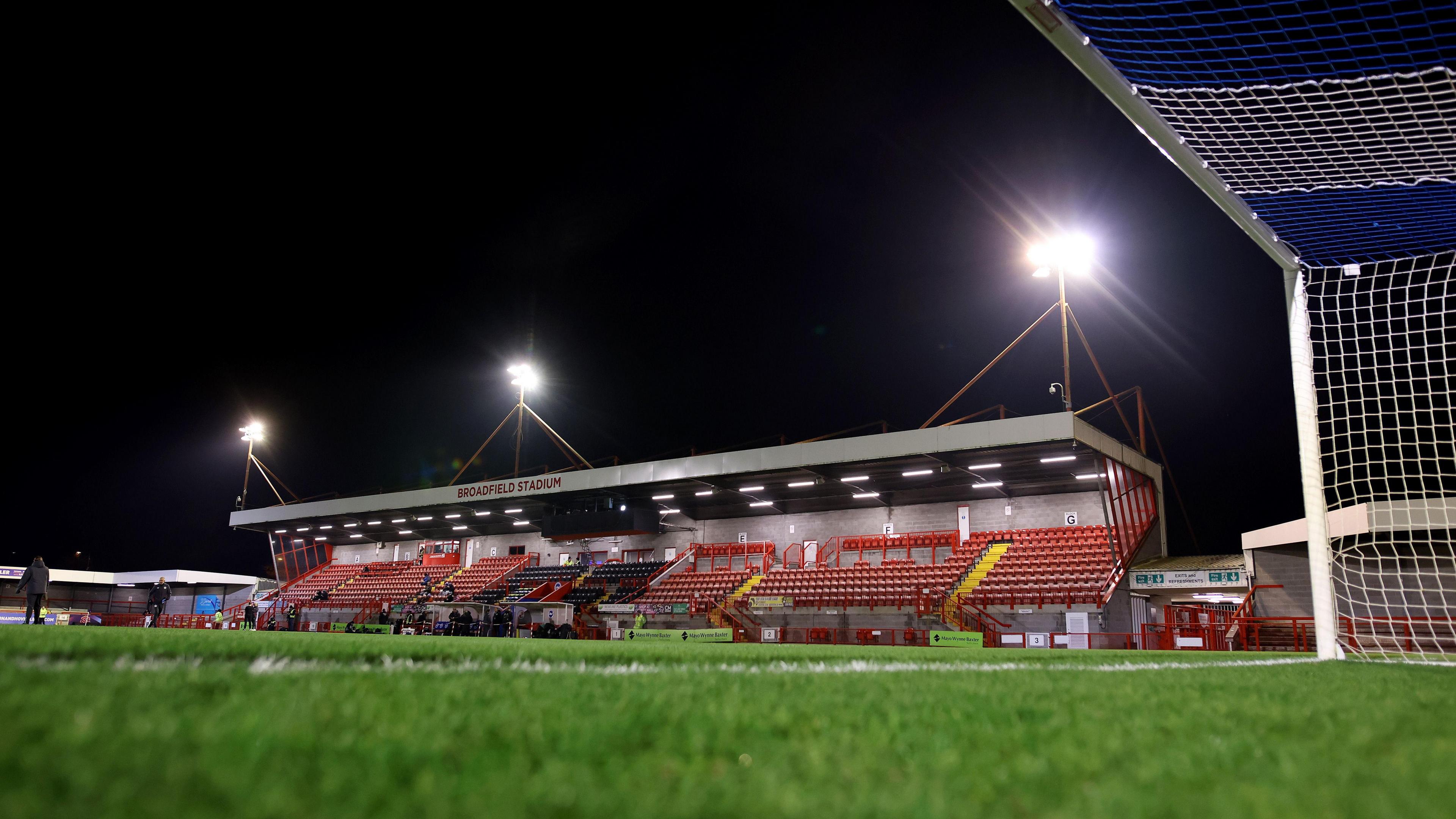 The Broadfield Stadium at night, with floodlights on