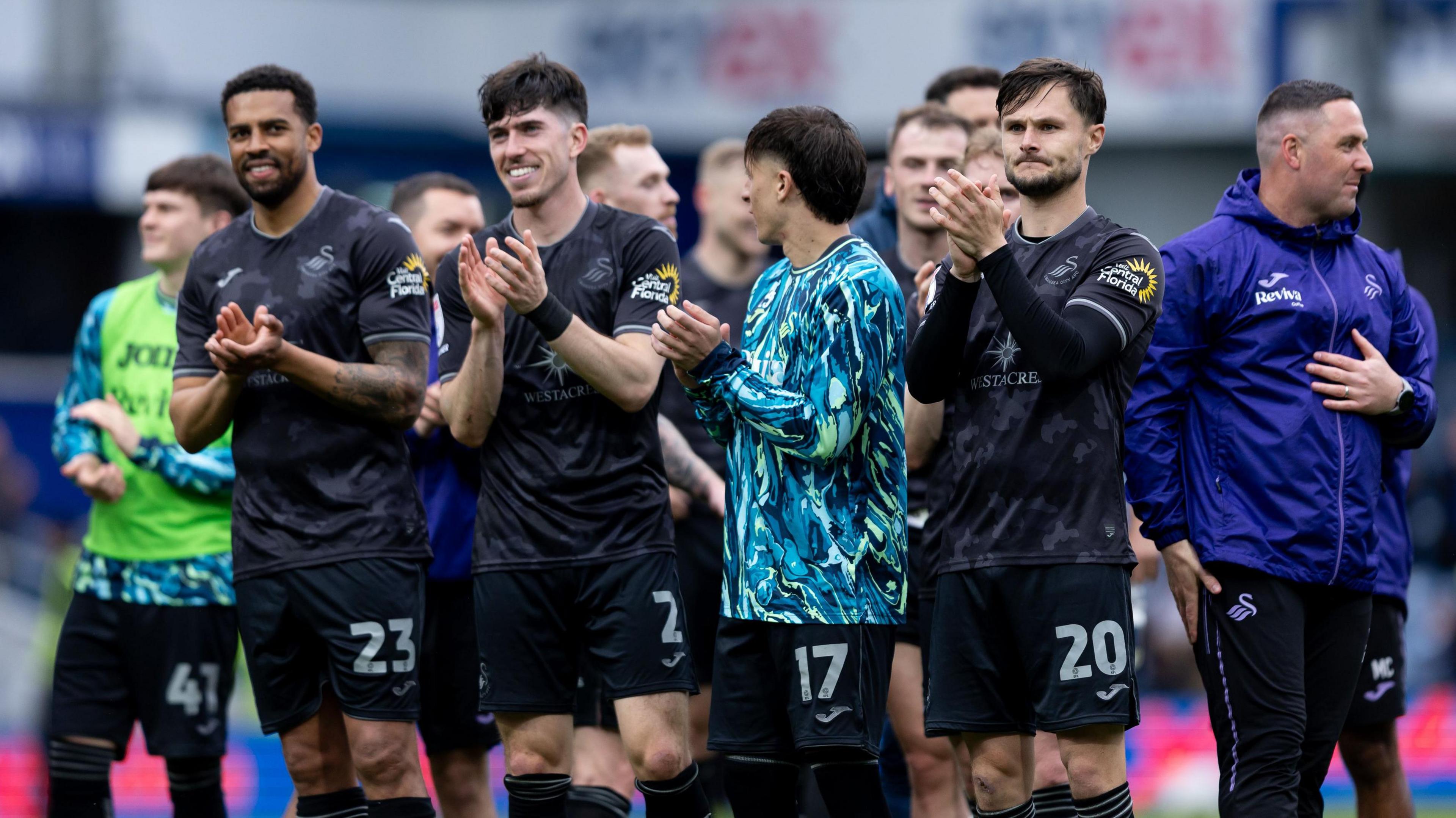Swansea players celebrate victory at QPR last month