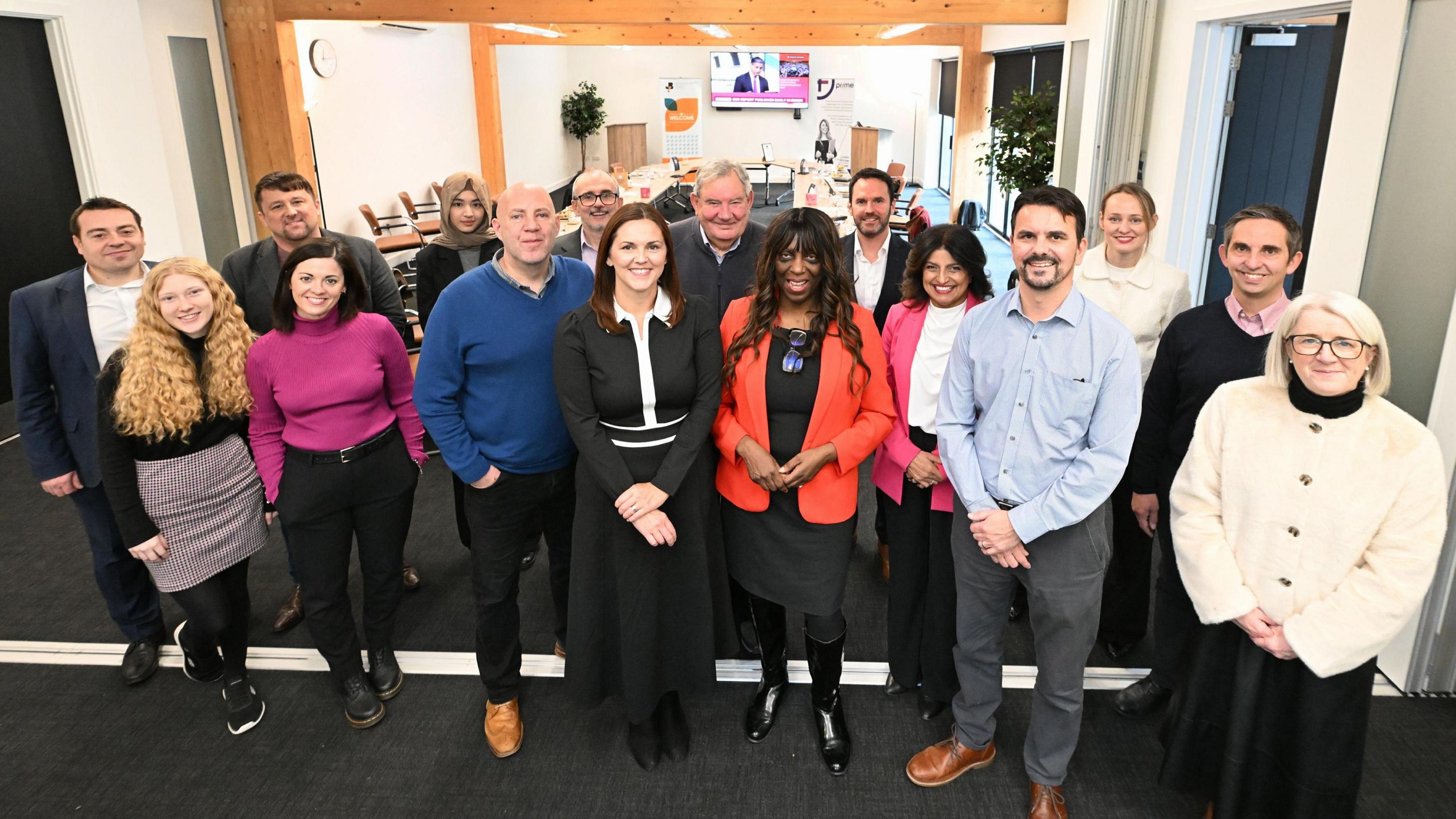 Members of Coventry and Warwickshire Chamber of Commerce stand in a group and face the camera. They are in a conference room.