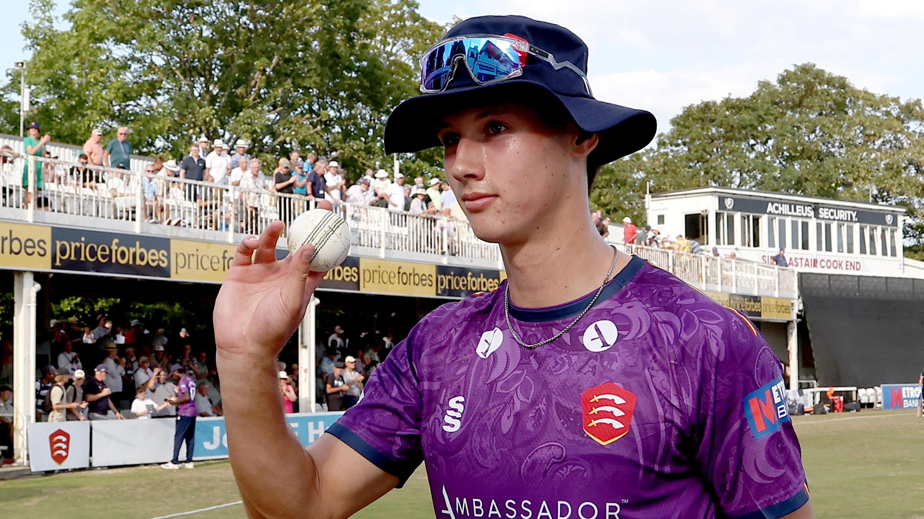 Charlie Bennett with the match ball after taking five wickets against Surrey