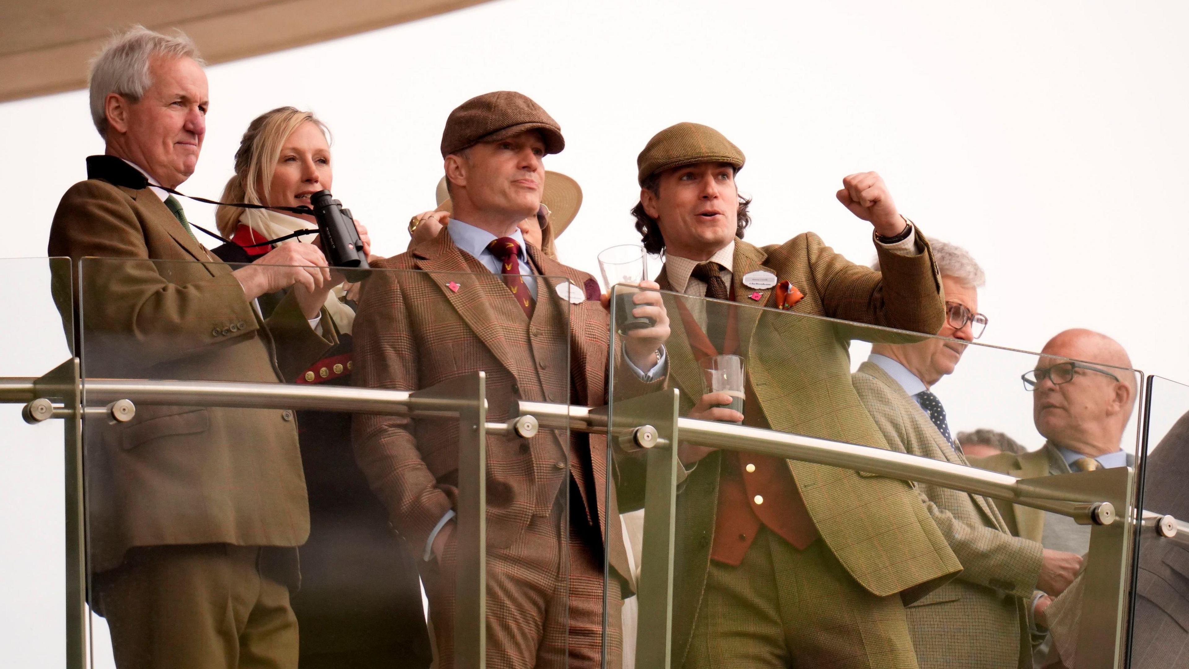 Henry Cavill with friends in the stands watching the racing.