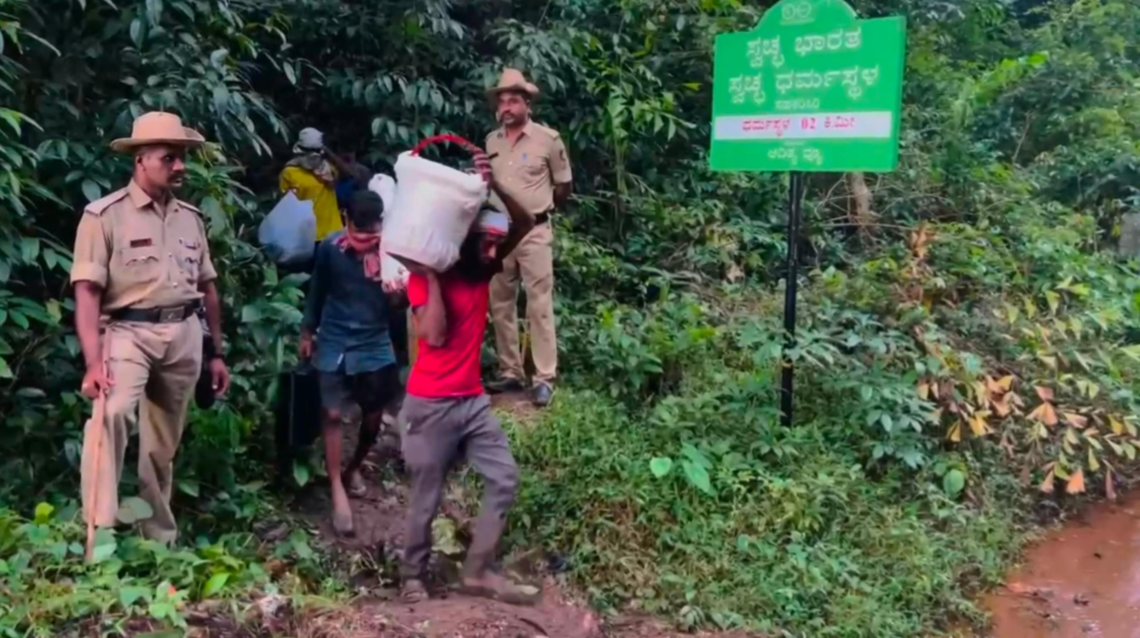 Taken on 4th August in the temple town of Dharmasthala in Karnataka, the photo shows diggers carrying packets and a bucket containing human remains found at a spot identified by the whistleblower
