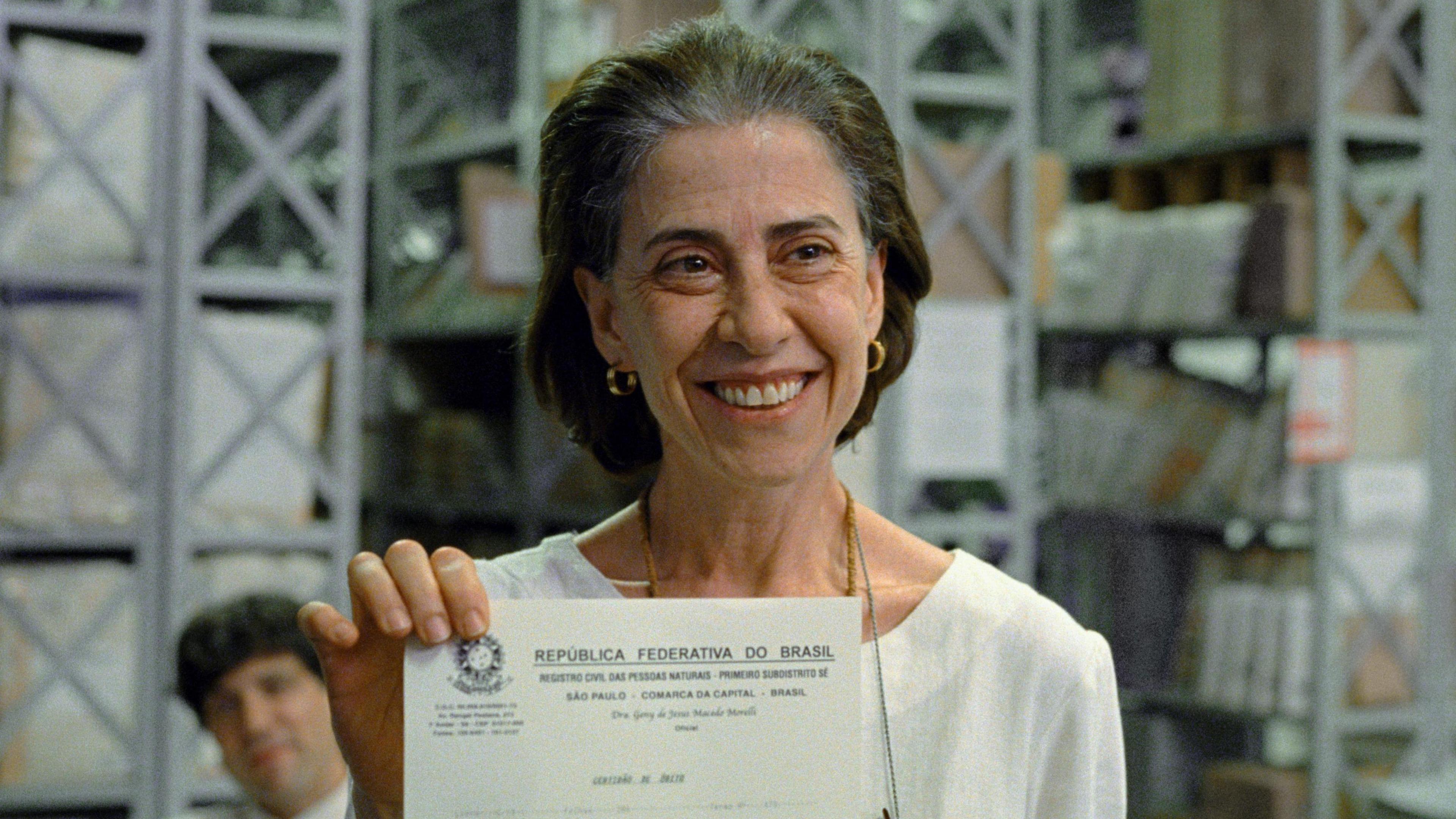 Eunice (played by Fernanda Torres) holding up her husband's death certificate