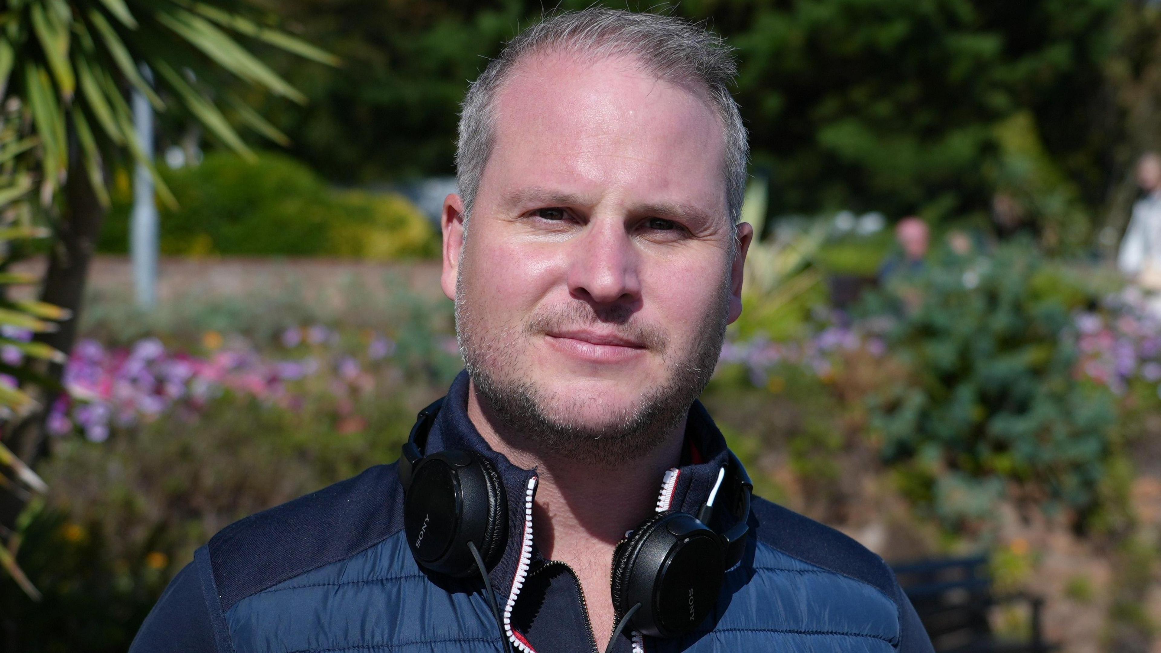 Man in front of green garden 