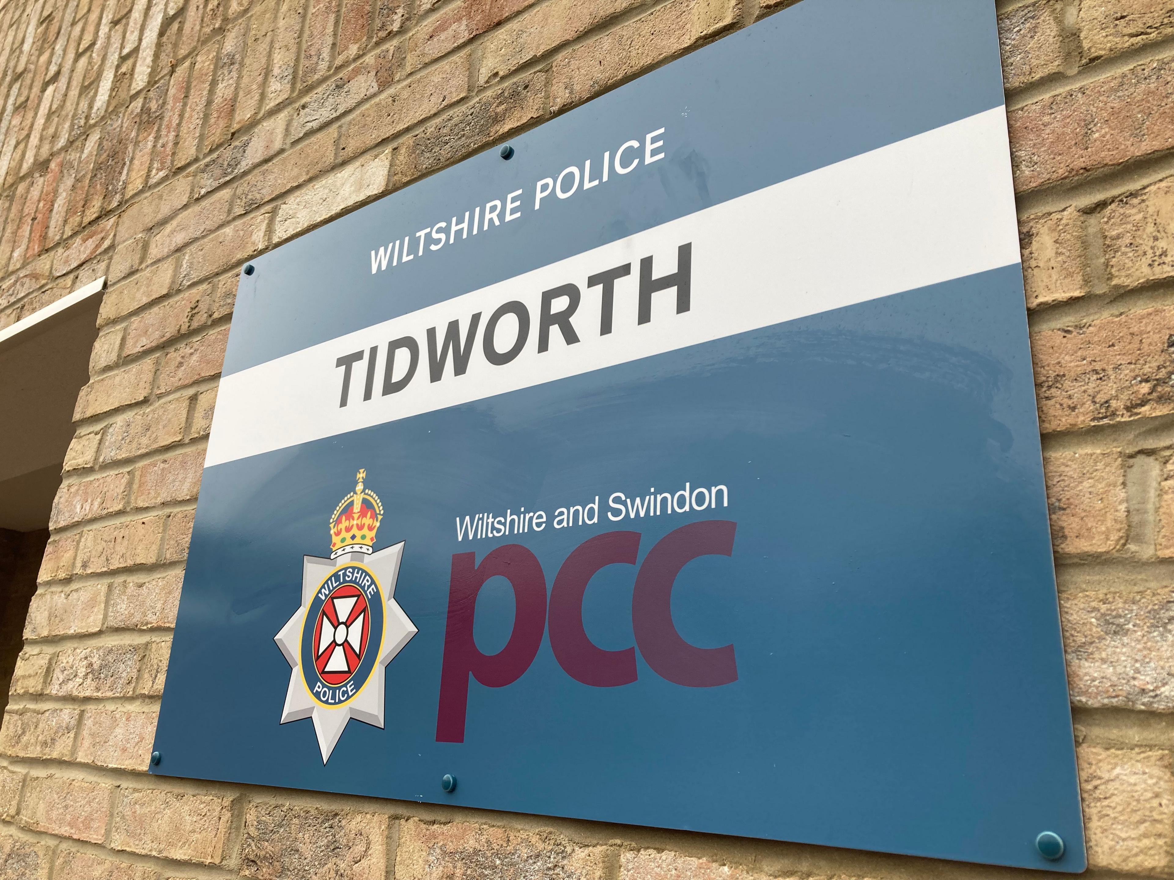 A Wiltshire Police sign on a brick building