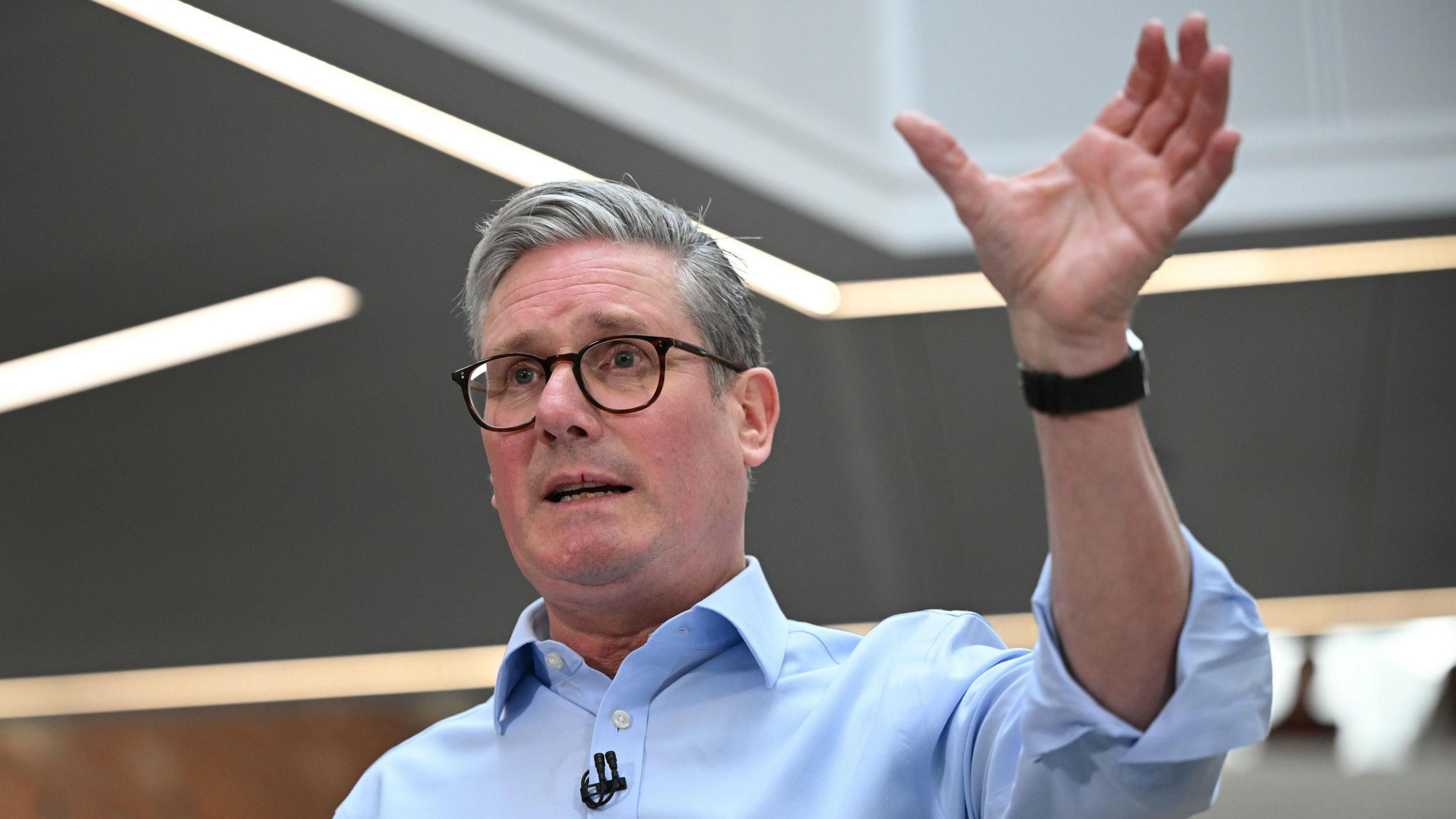 Sir Keir Starmer raises his hand while giving a speech in Hull.