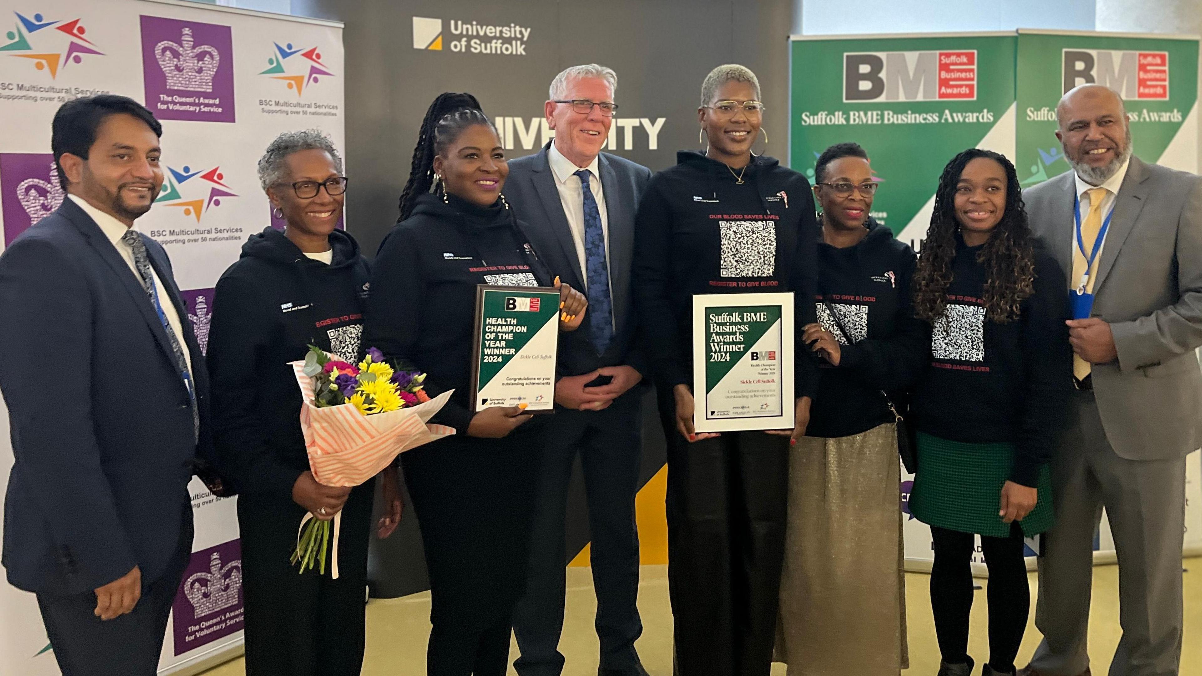 Five women from Sickle cell Suffolk stand with their award certificates with members of BSC Multicultural Support Services and the award sponsor, Brian Tobin from Iceni Ipswich