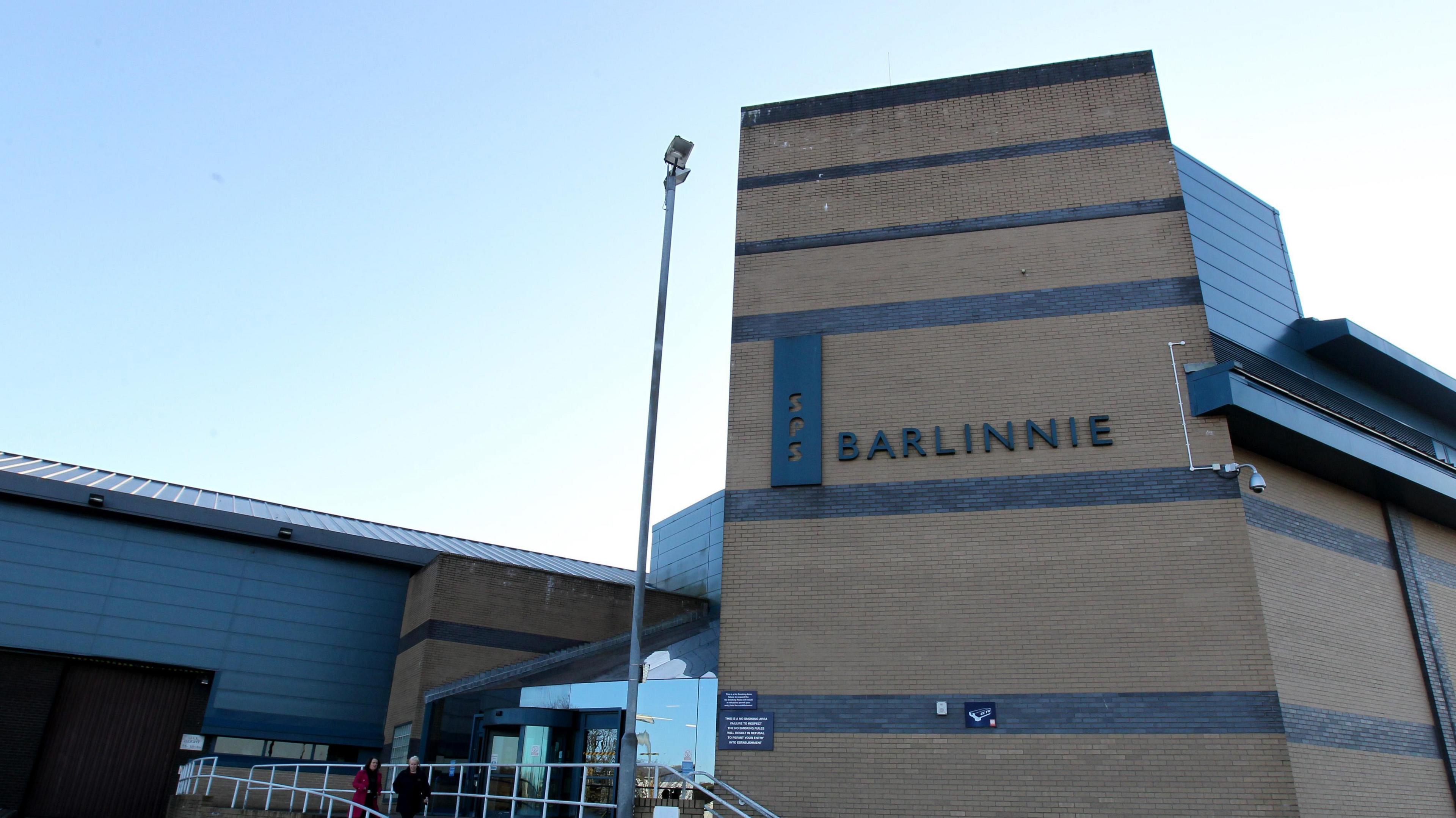 The front door of HMP Barlinnie. It is a modern brick and glass building.