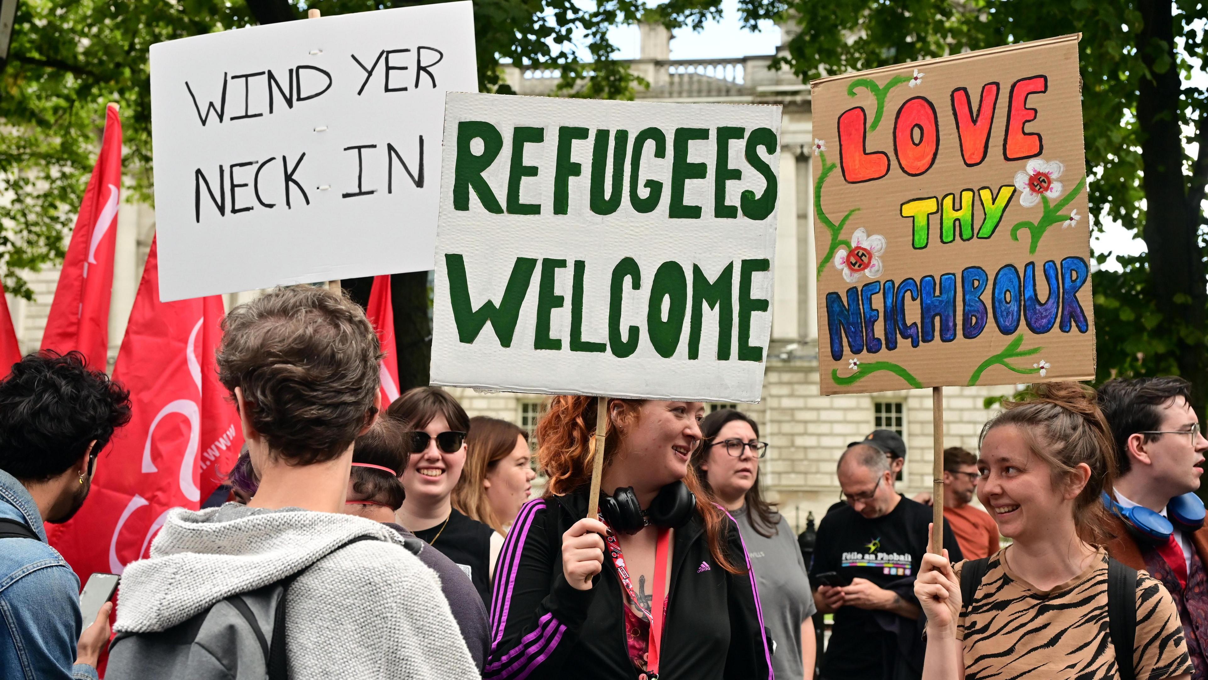 Protesters outside Belfast City Hall with placards reading refugees welcome and love thy neighbour