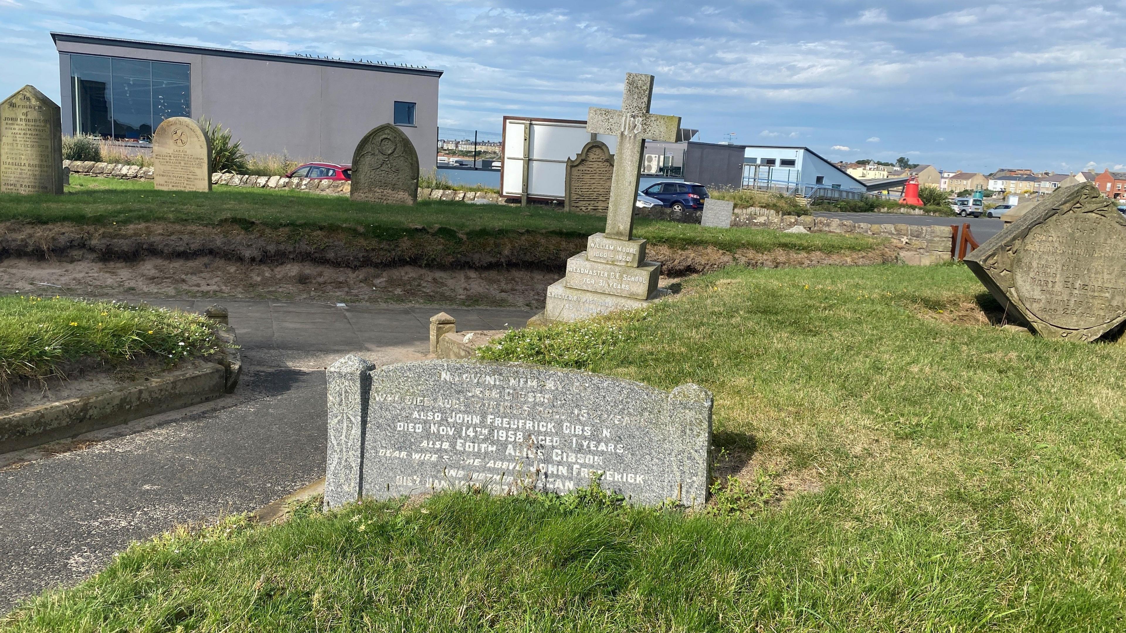 A gravestone stuck into the ground and hardly visible 