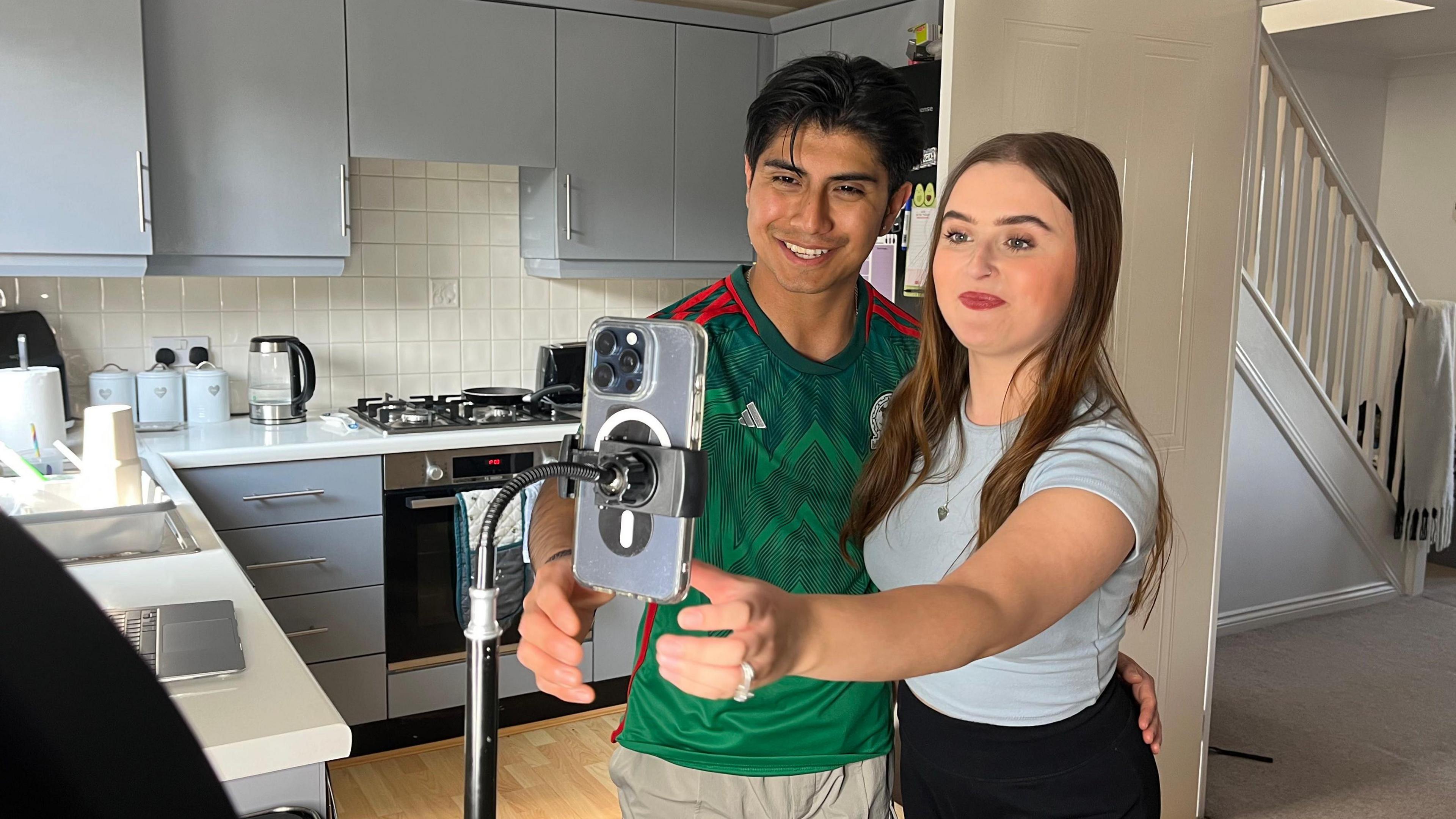 Holly and Diego record a TikTok video in their kitchen.