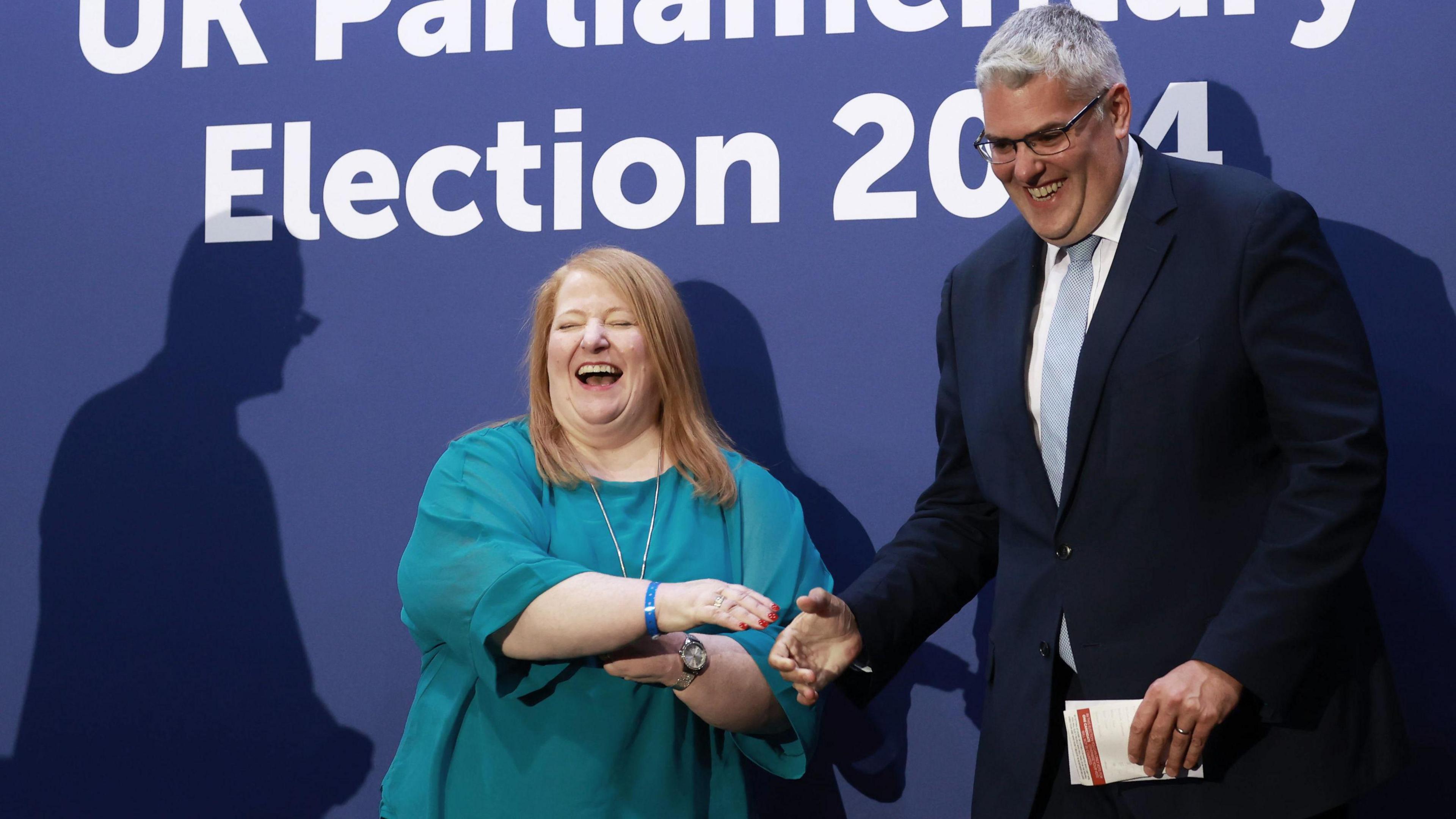 DUP leader Gavin Robinson (right) shakes hands with Alliance Party leader Naomi Long (centre).