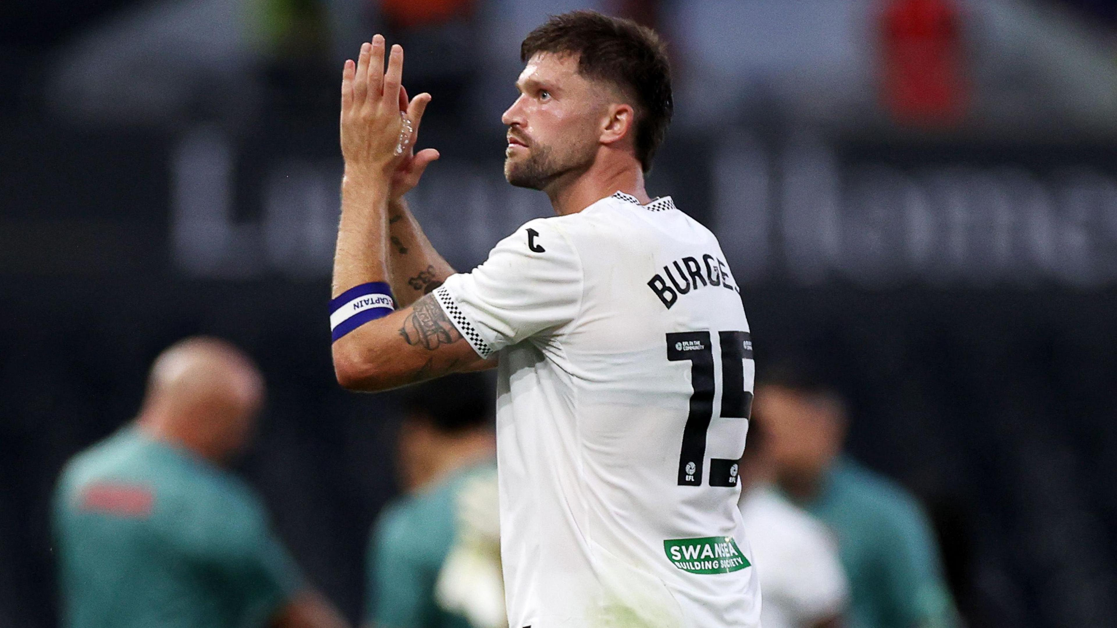 Swansea defender Cameron Burgess applauds crowd