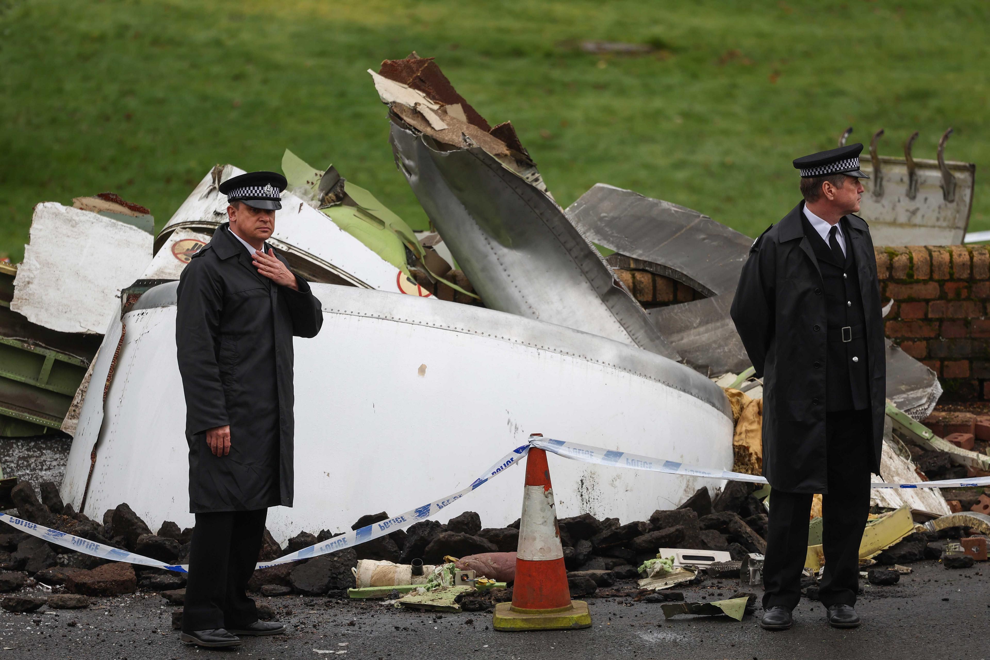 Actors playing police officers stand in front of wreckage of the plane while filming the Sky TV drama in Bathgate, West Lothian