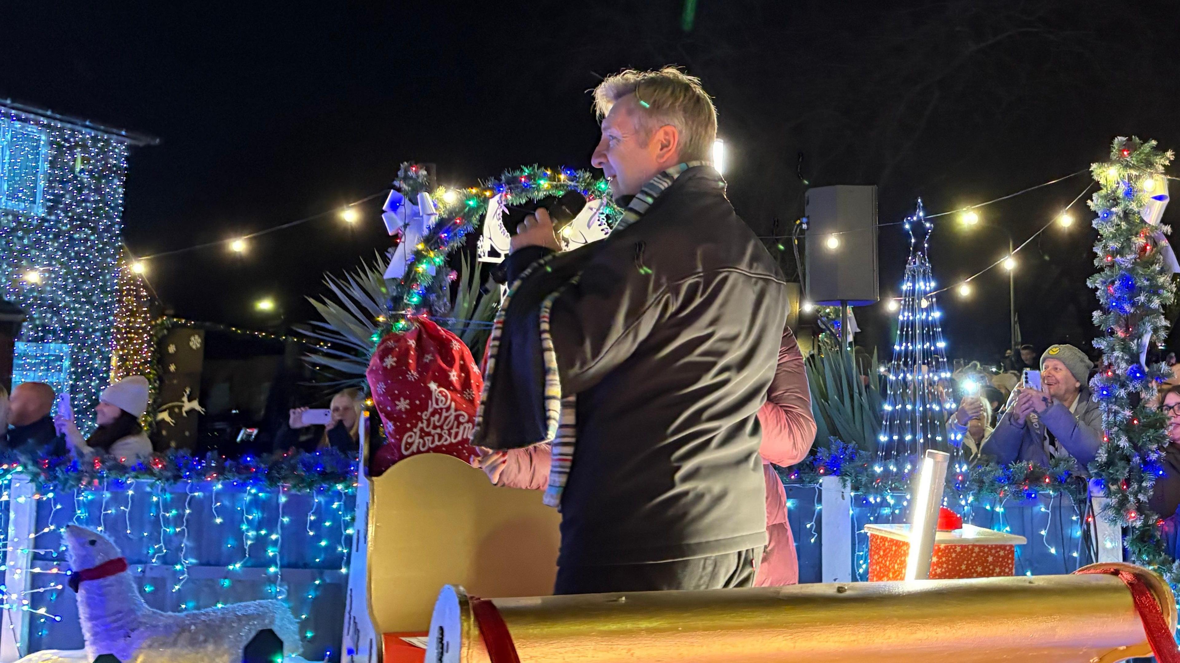 Christmas lights switch-on in Nuthall with Christopher Dean talking into a microphone