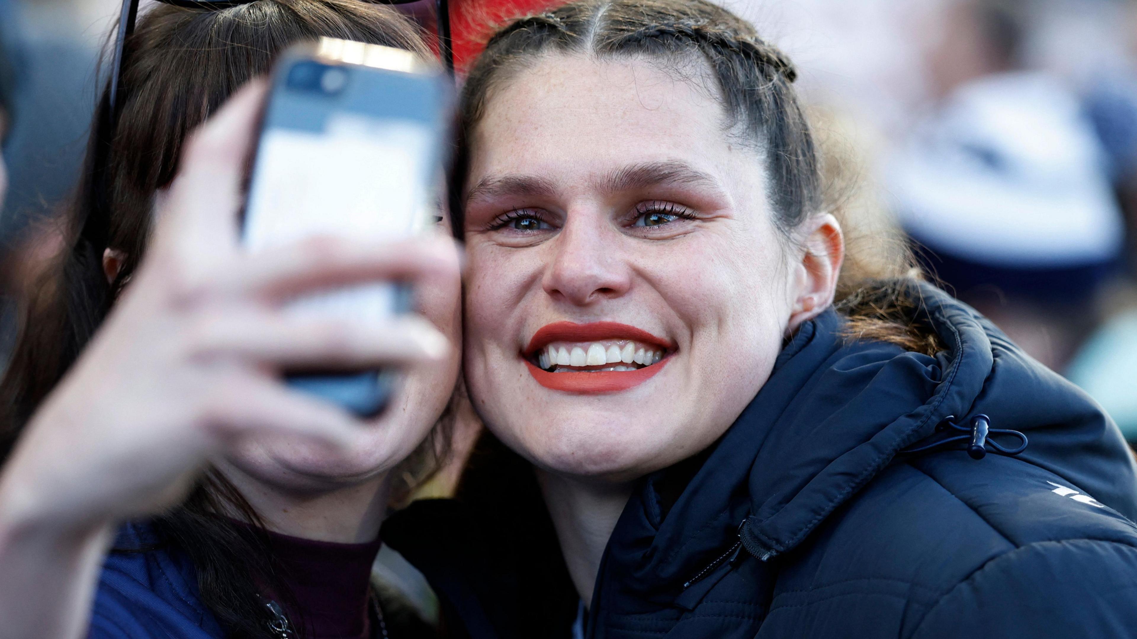 Rugby star Ilona Maher poses with a fan for a selfie