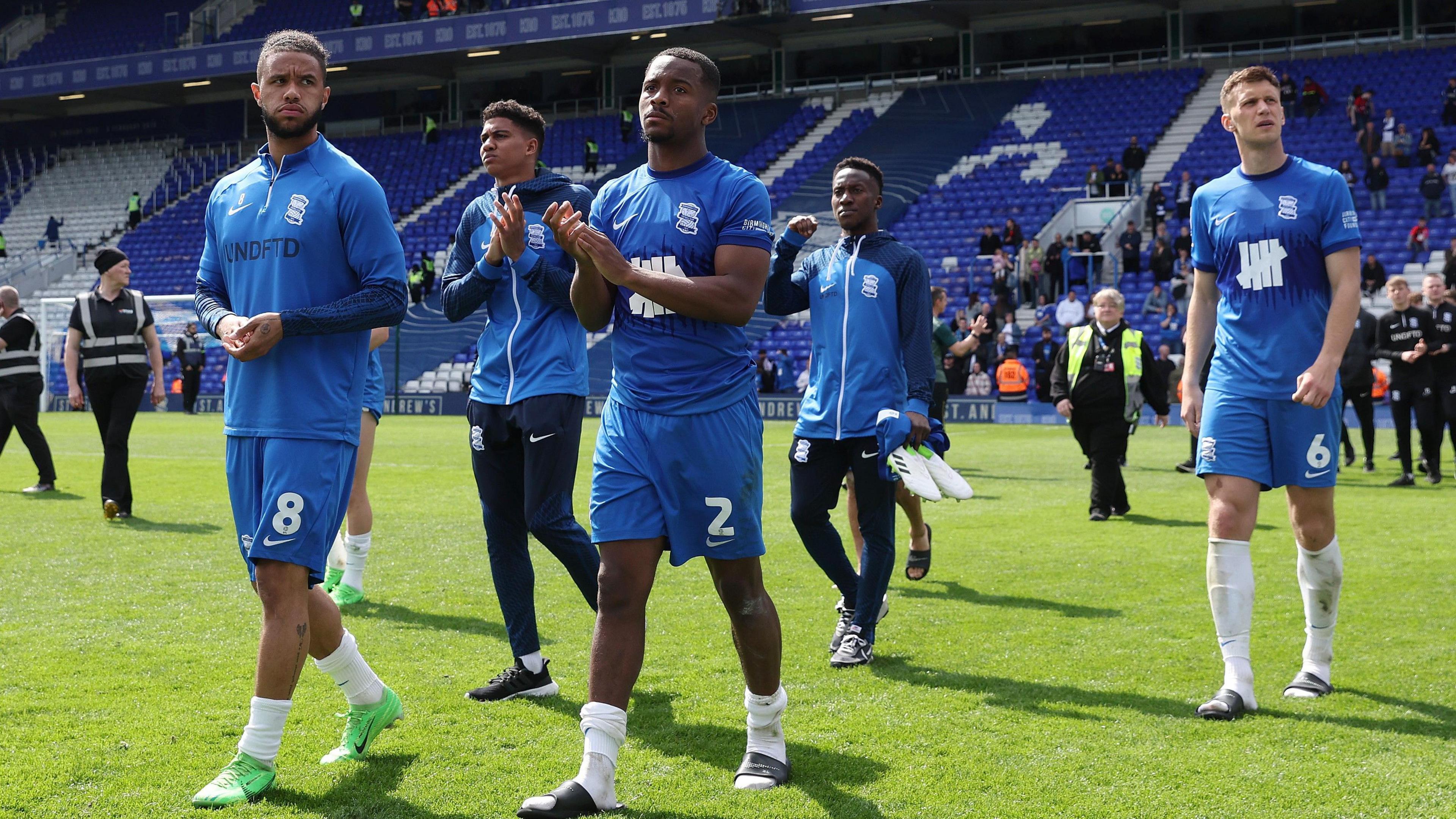 Birmingham players, wearing their blue strip and looking sombre, applaud the fans following their 1-0 win over Norwich.