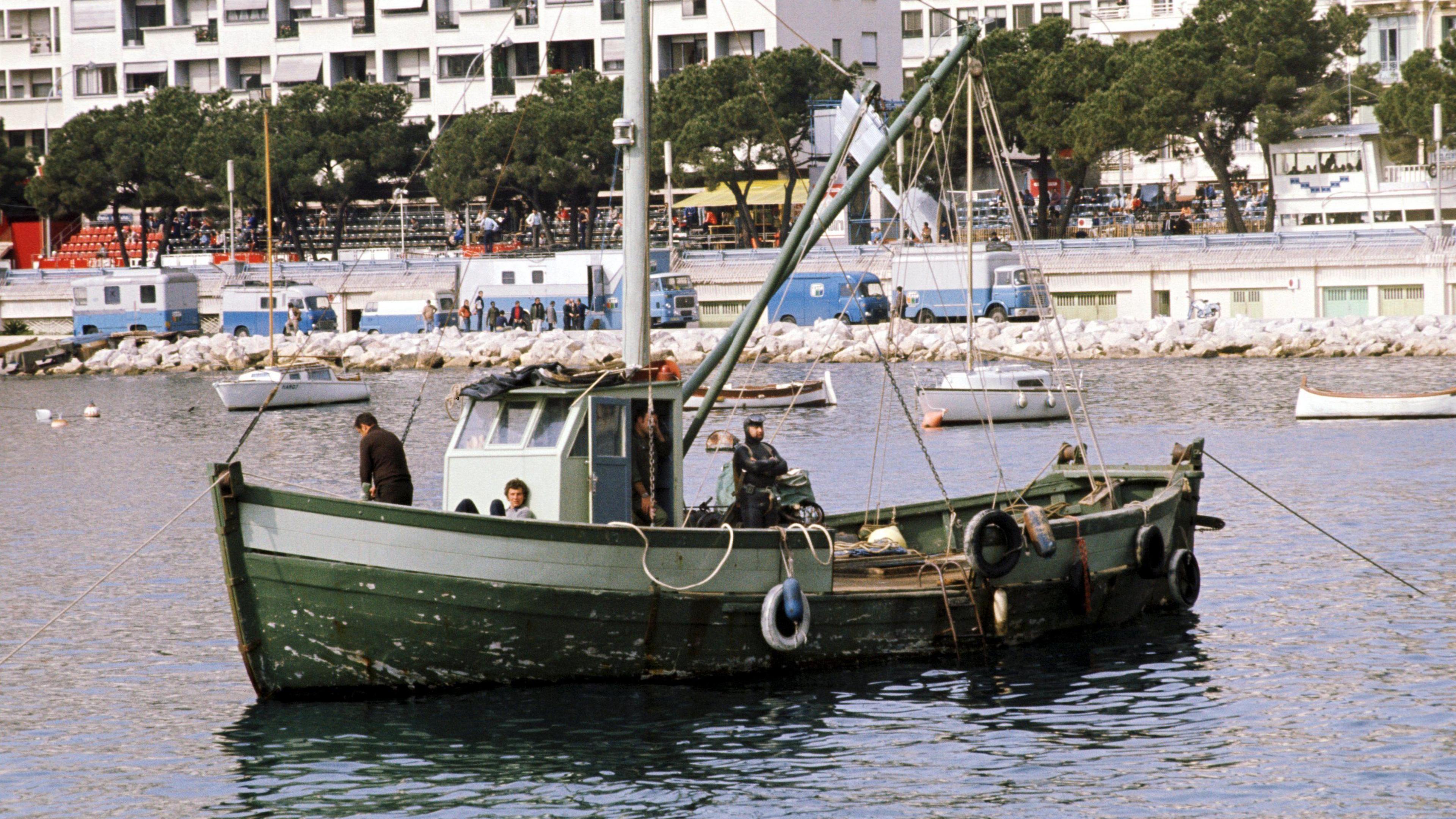 A frogman waits on a boat in case any cars crash into the harbour in 1972