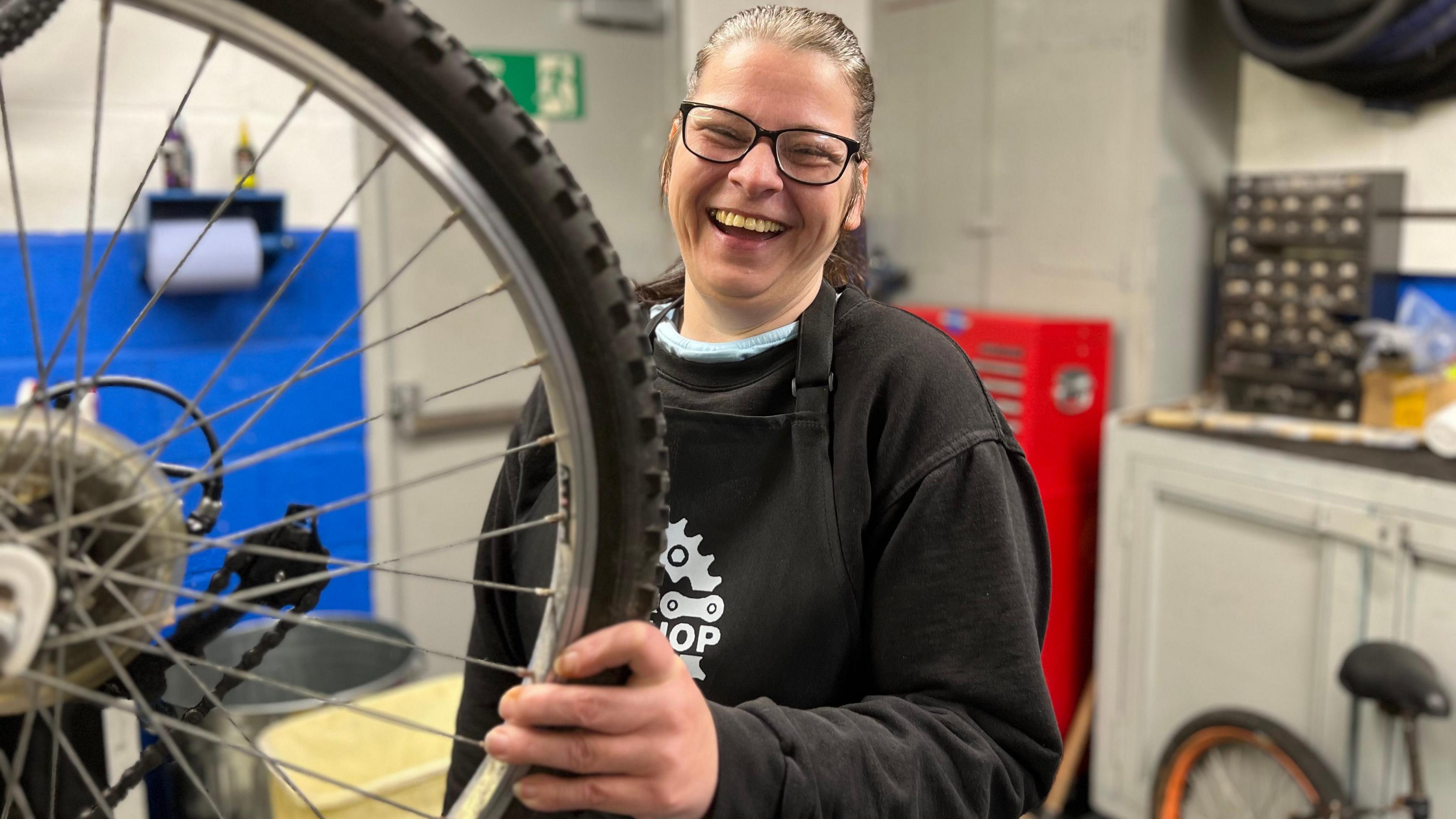 A woman  working on a bicycle in a repair shop 