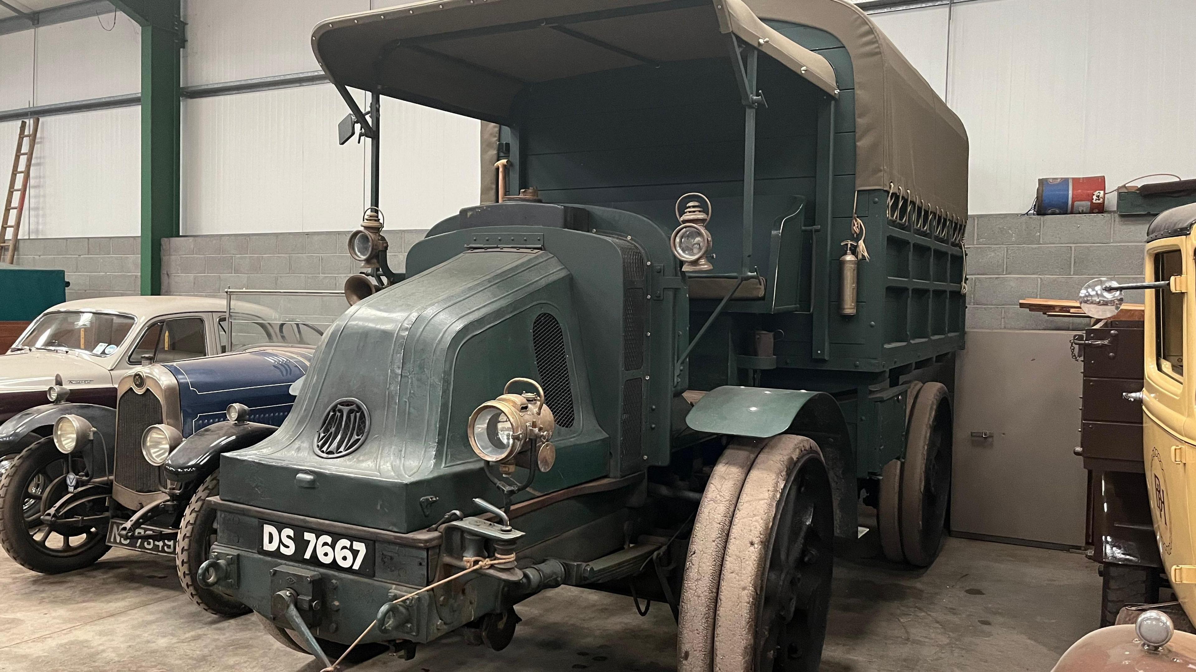 A dark blue-green four-wheel drive army truck with soft-top roof and registration plate DS 7667