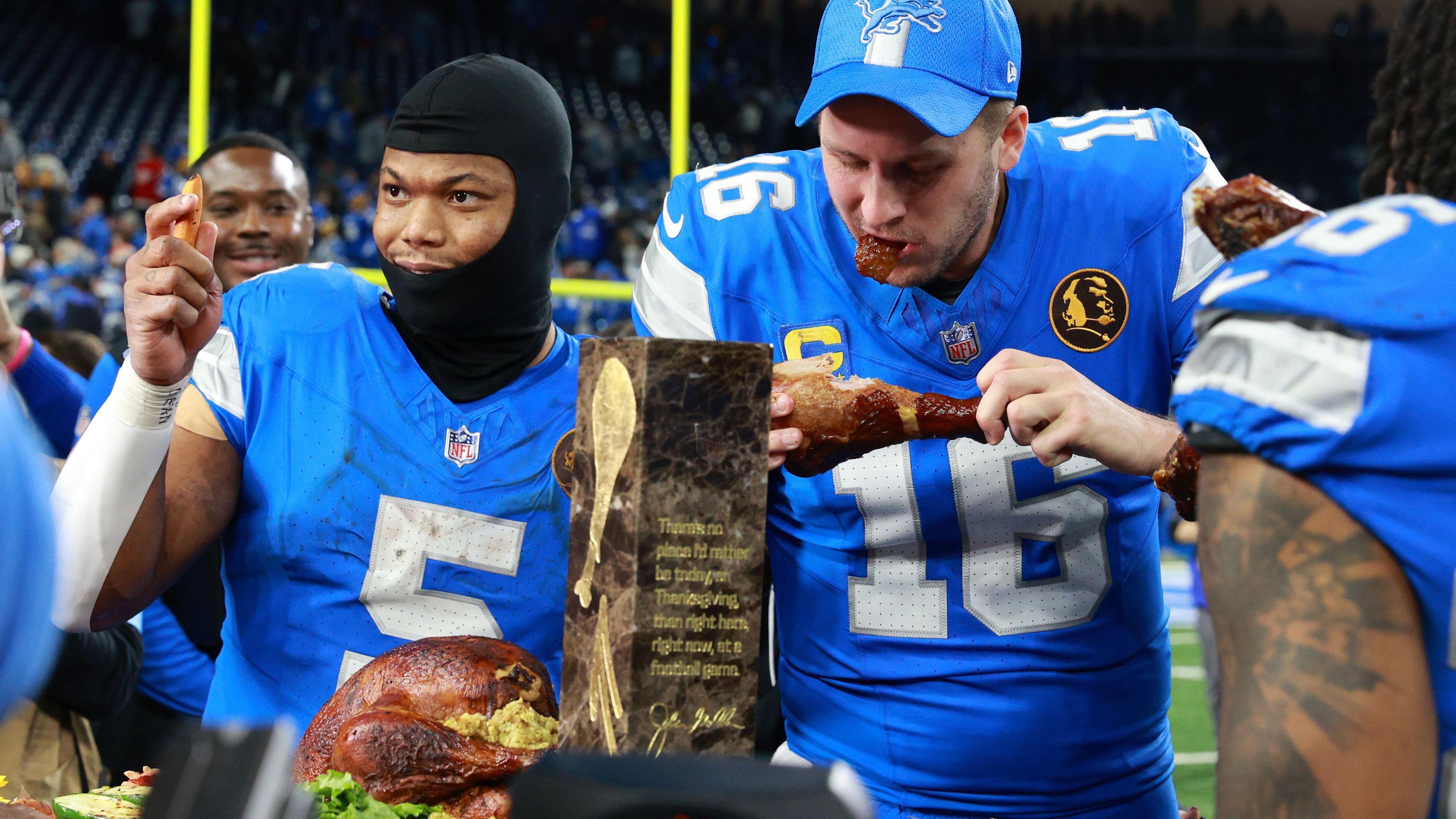 Detroit Lions quarterback Jared Goff and running back David Montgomery take a turkey leg after their win