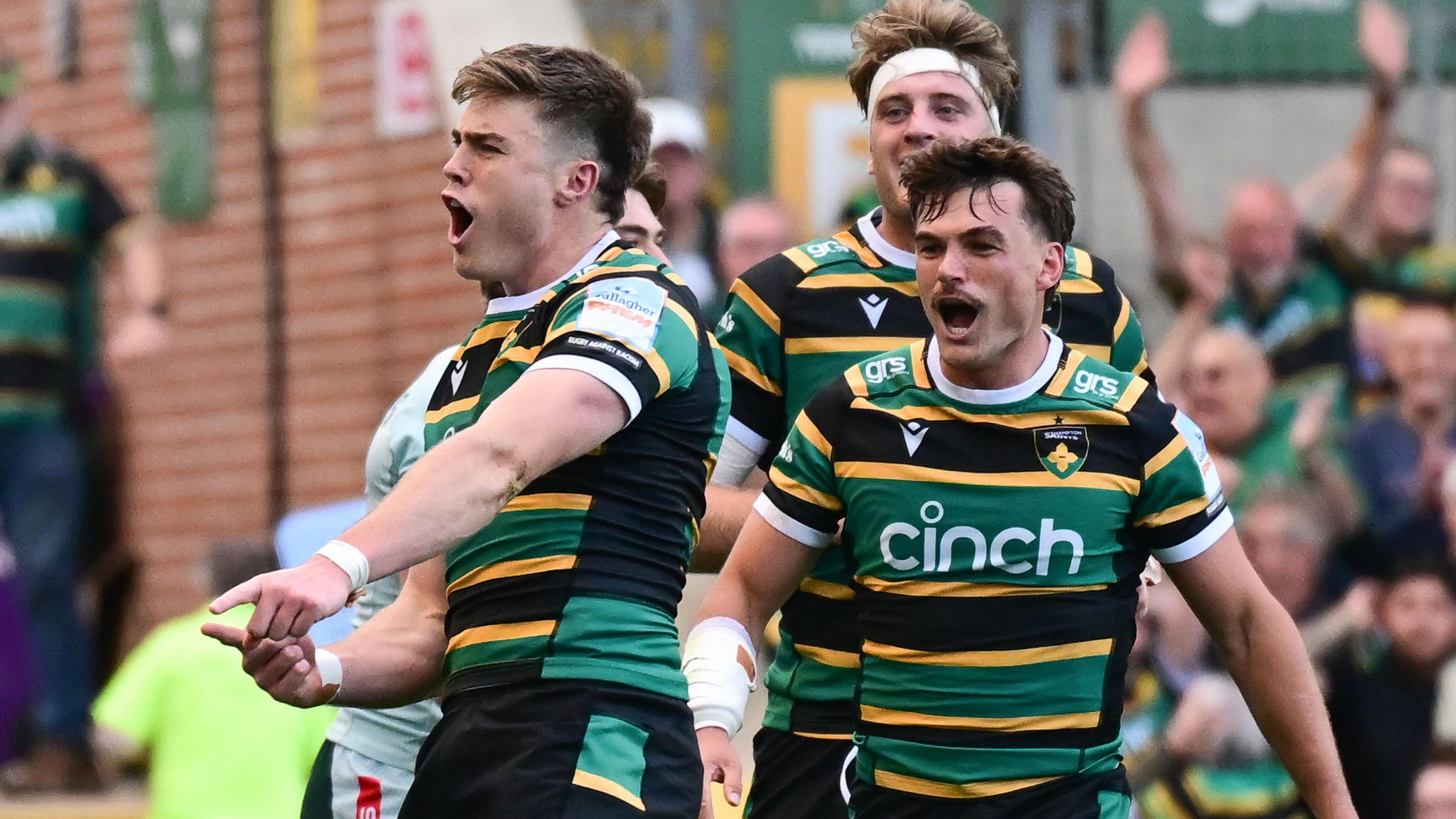 Northampton Saints wing Tommy Freeman (14) celebrates, wearing his black, yellow and green striped Northampton Saints kit, during the Prem Rugby play-off against Leicester Tigers, as team-mates join in behind him