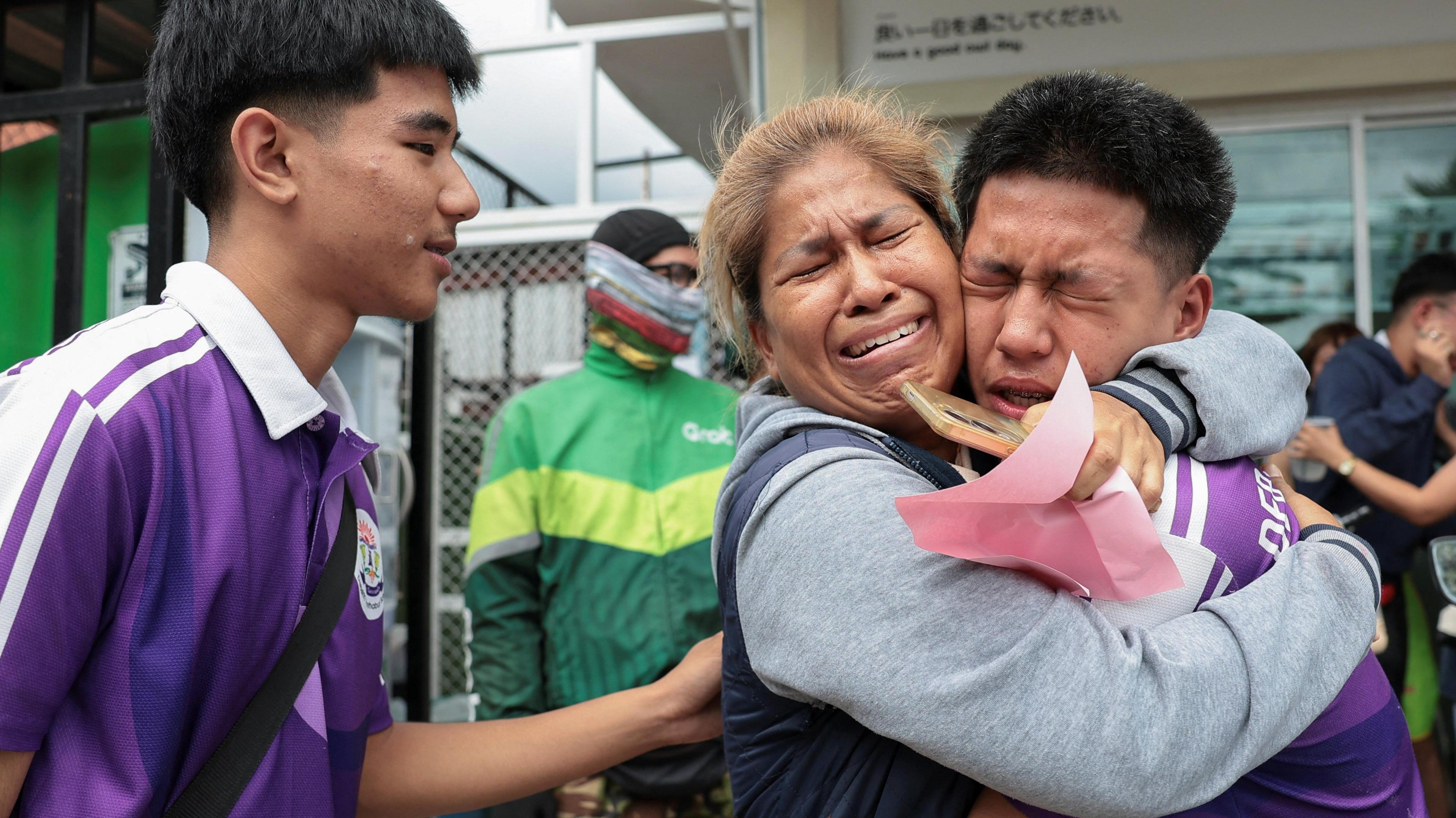 Student reacts with relative after being evacuated from Debsirin Nonthaburi School, following a shooting incident at the school