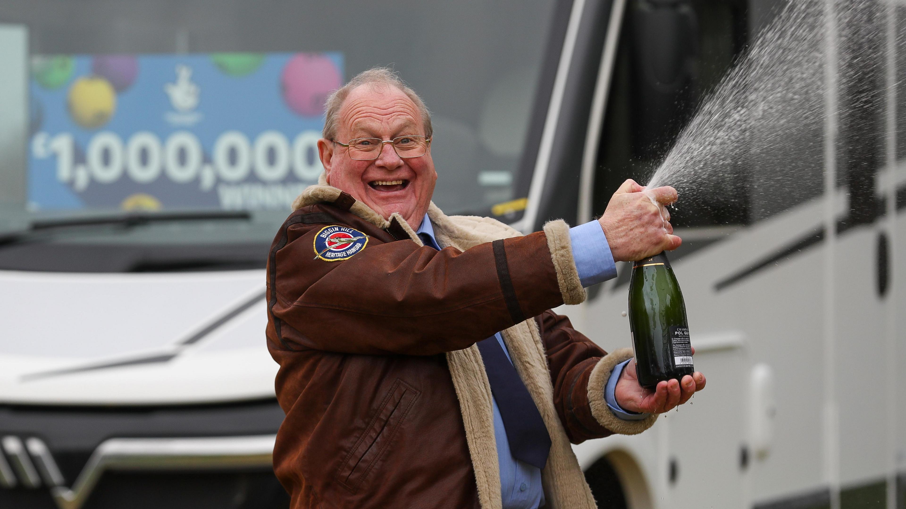 Steve Glover popping champagne in front of new motorhome