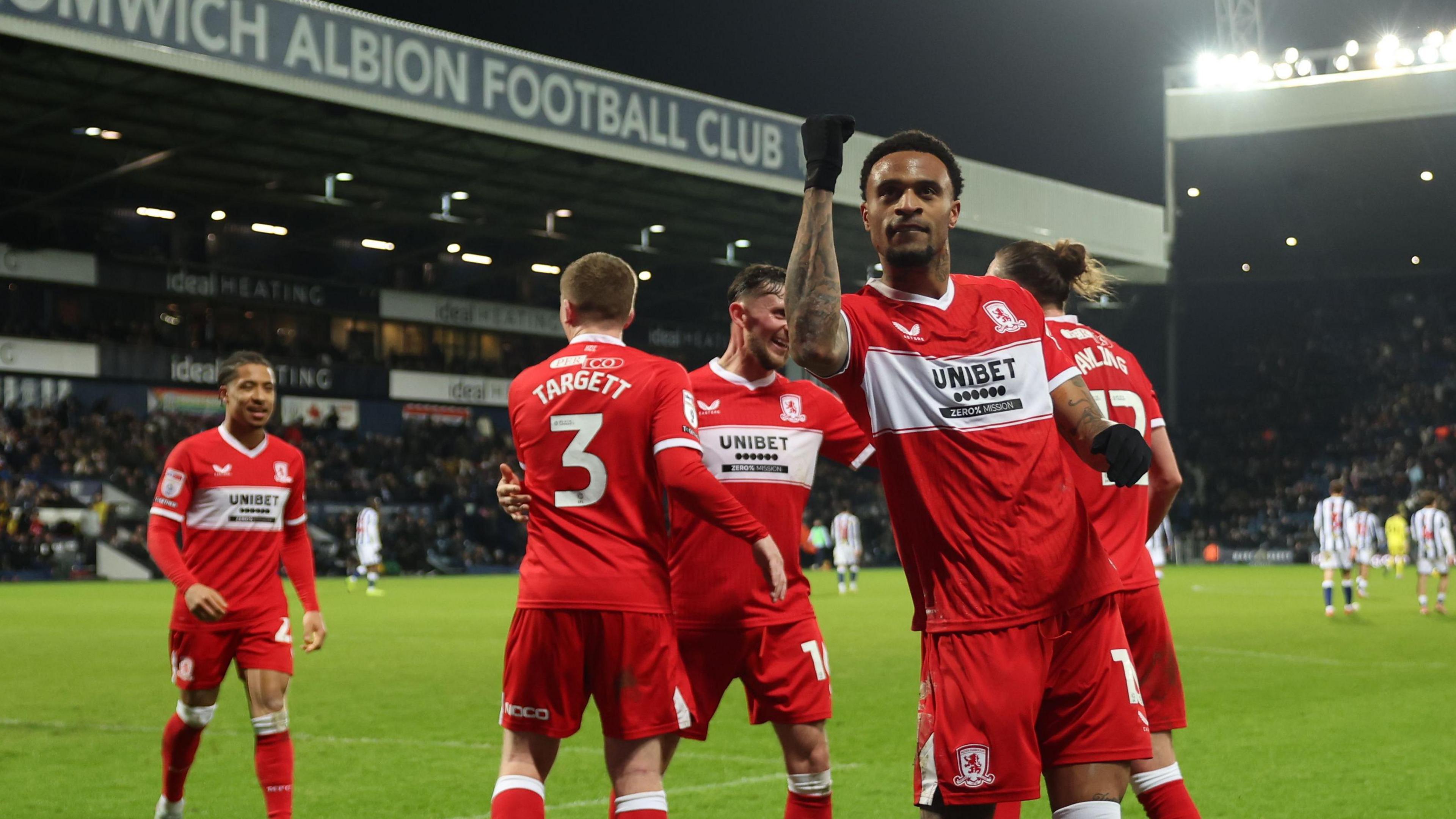 Delano Burgzorg has his right arm lifted in celebration after his late winner for Middlesbrough with a few team-mates behind him