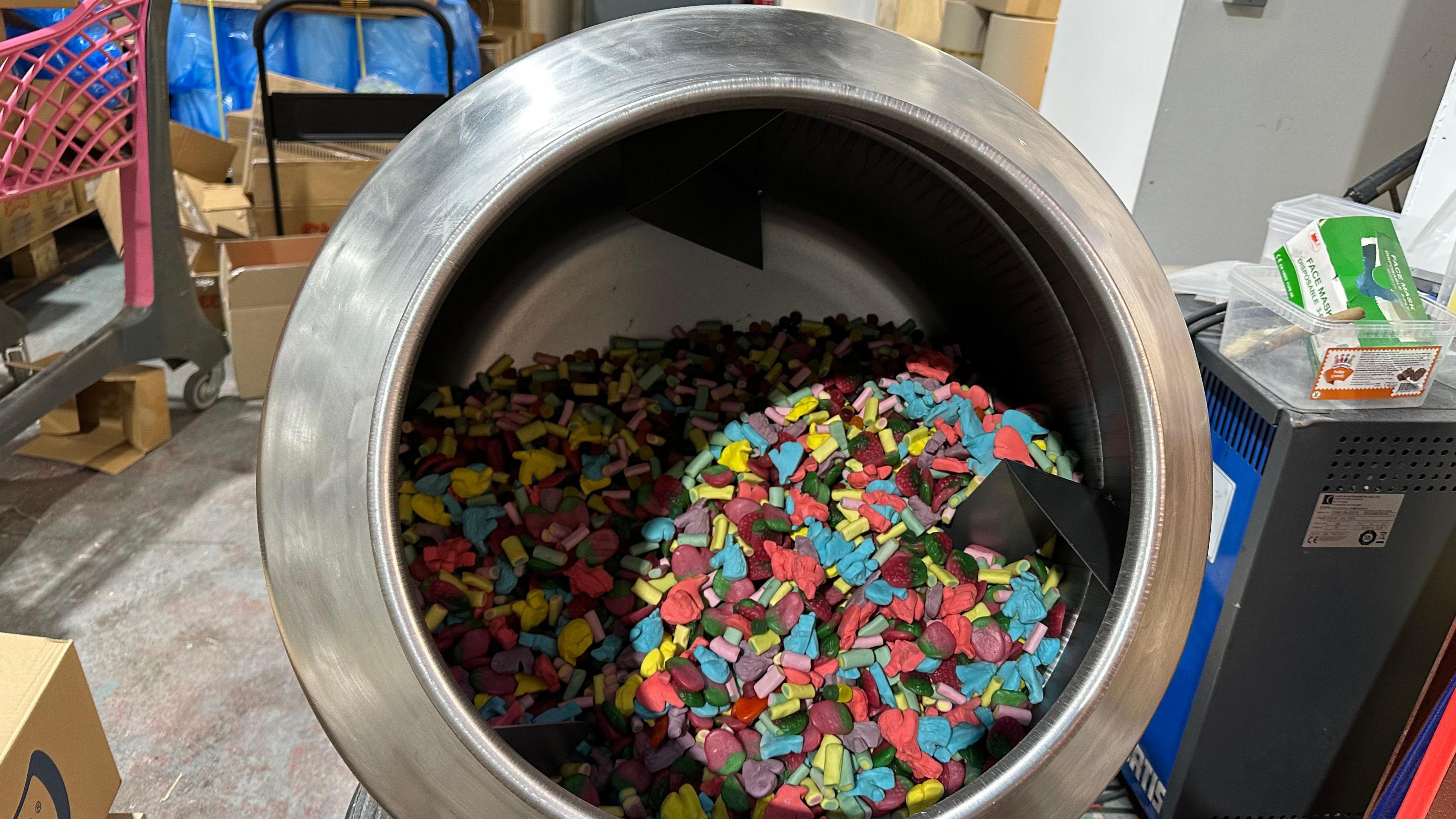 A cement mixer type machine half-filled with sweets.