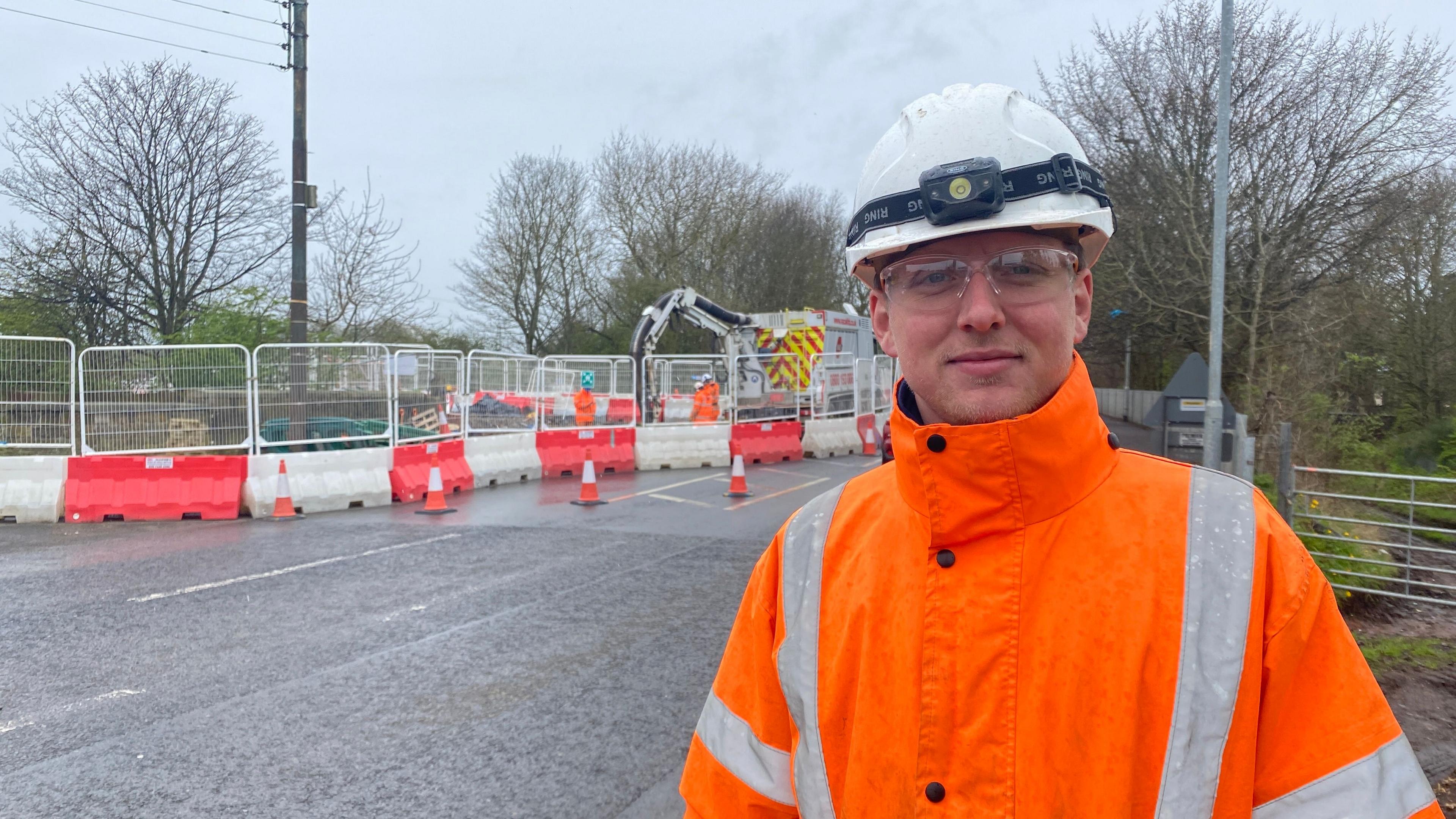 A man in a high vis jacket standing near some construction work