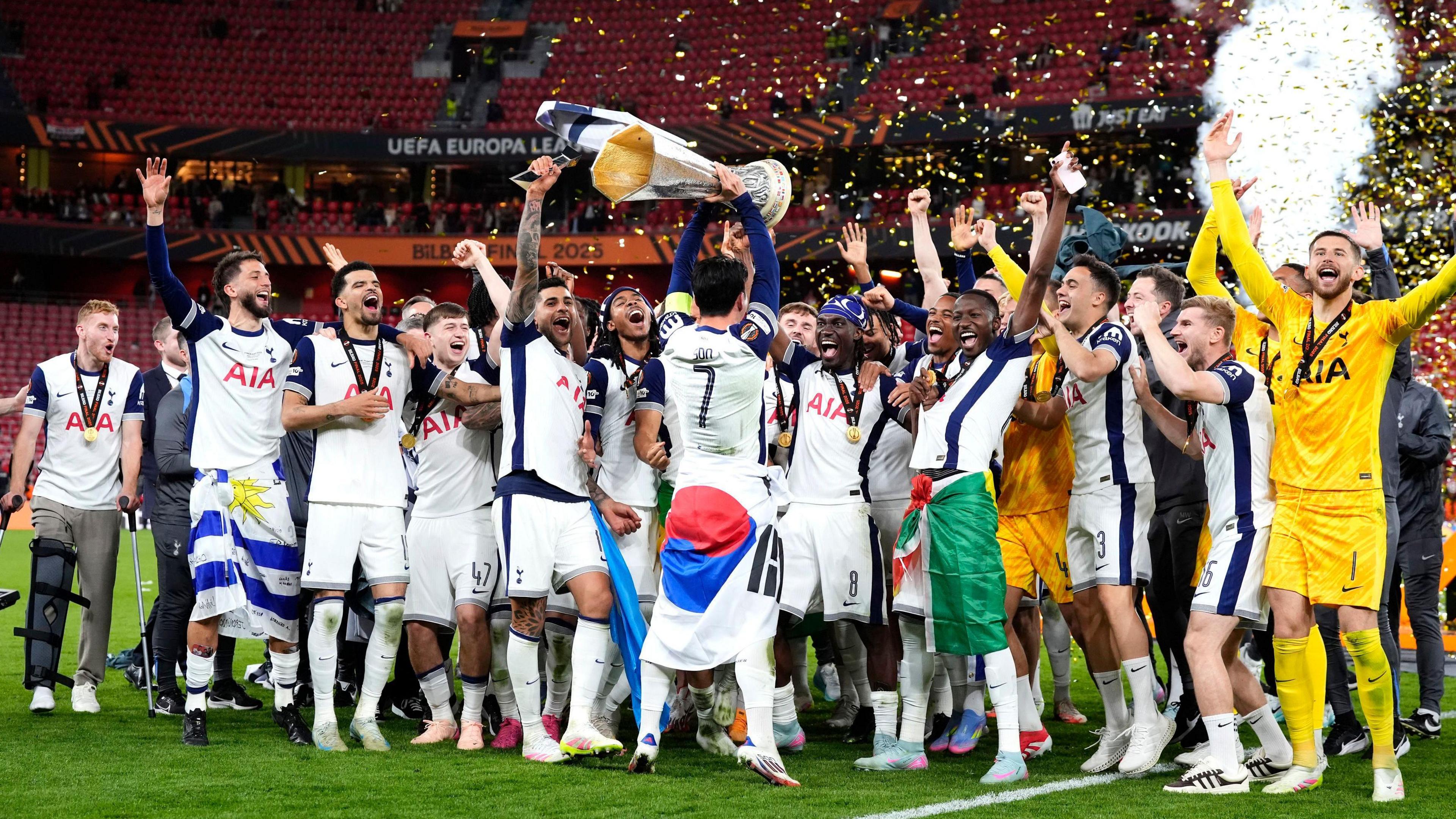 Spurs players celebrating their win holding the trophy