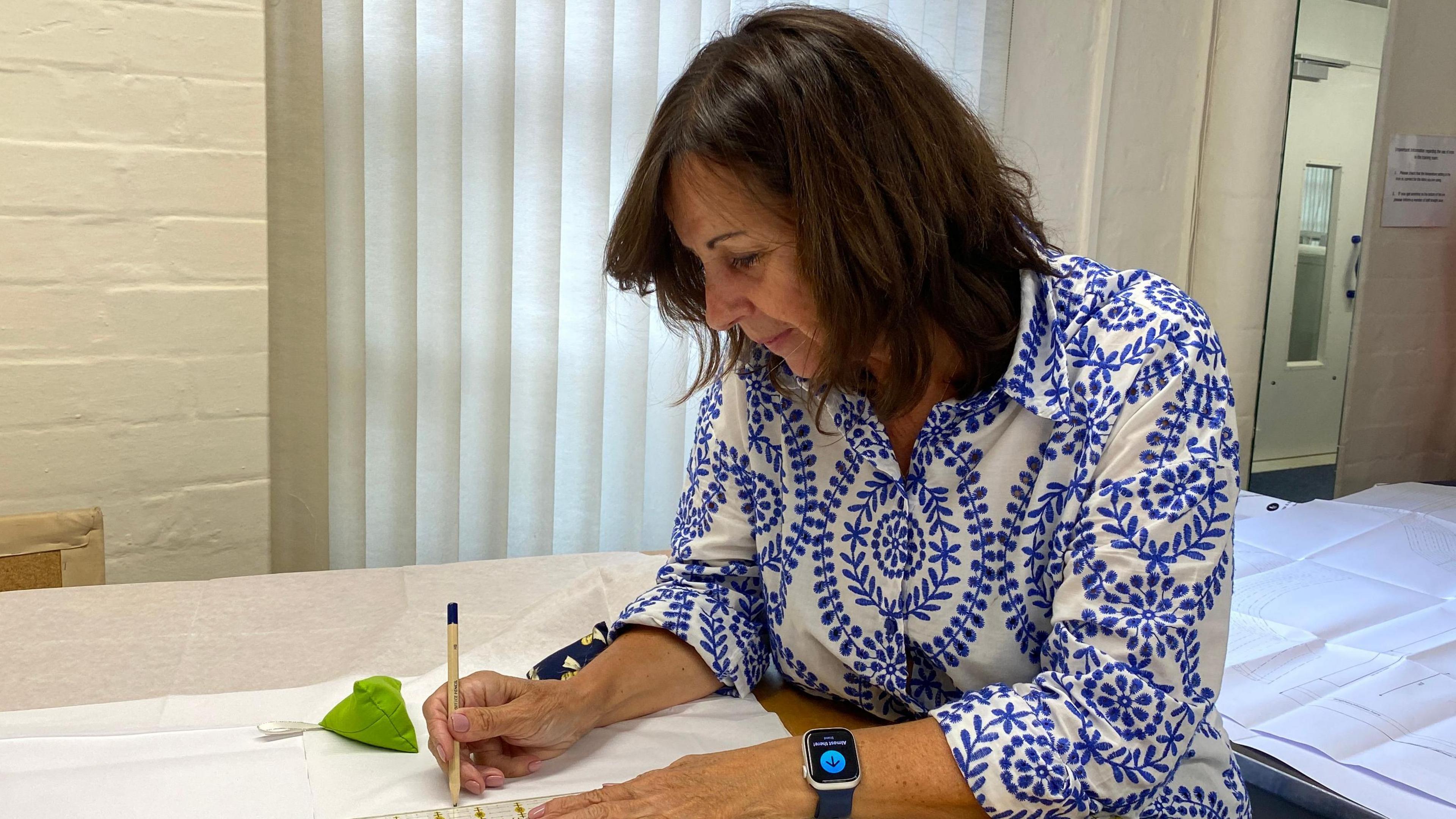 Karen Robinson draws on a dressmaking pattern at her sewing class. 