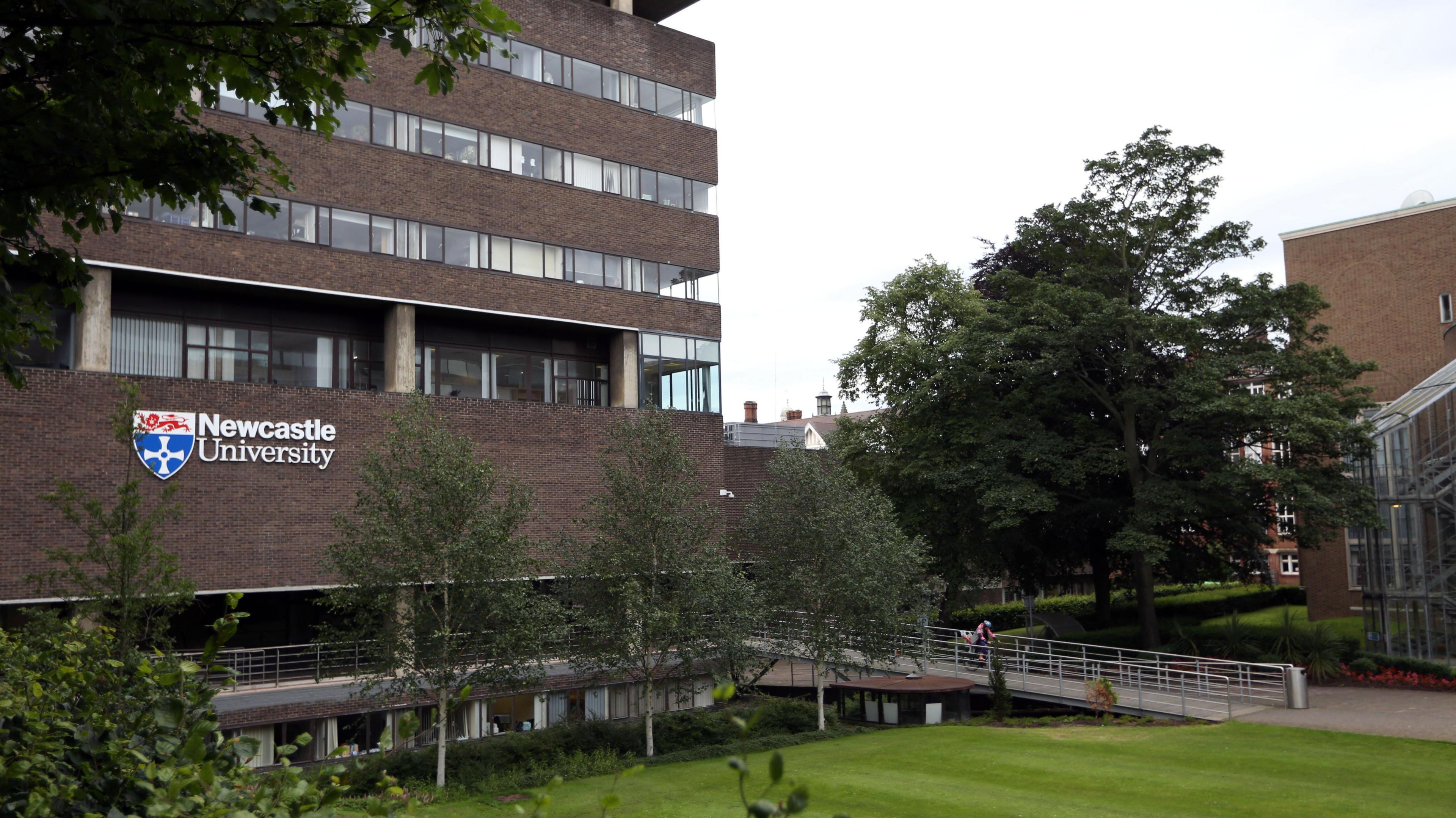 Claremont Tower, Newcastle University is a brown brick multi-storey building with the unversity's crest and logo.