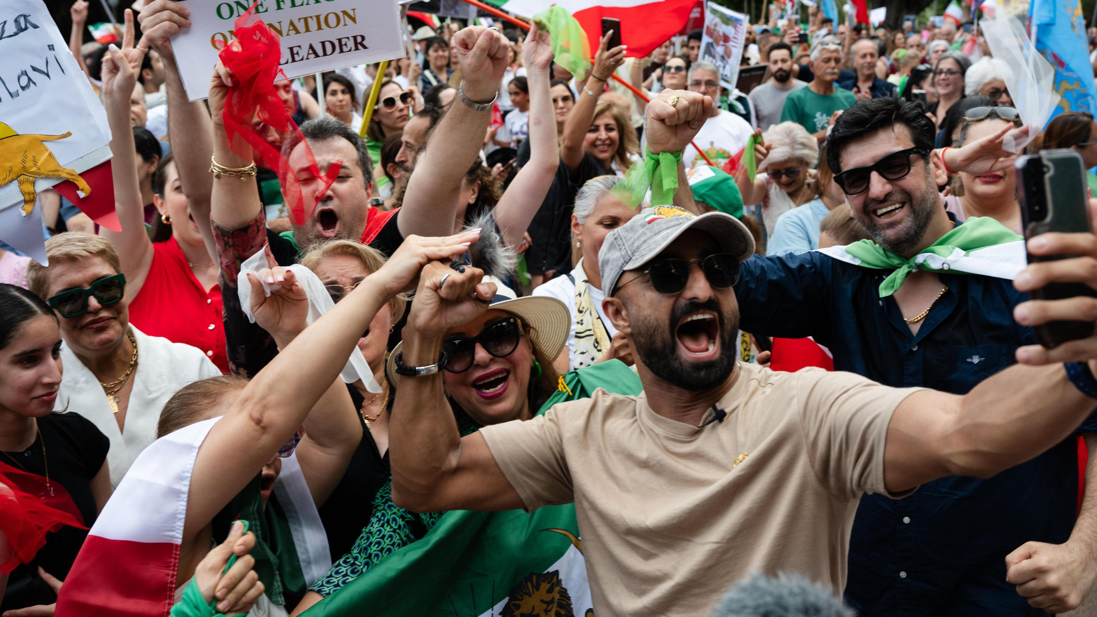 People celebrating with Iranian flags and smiling